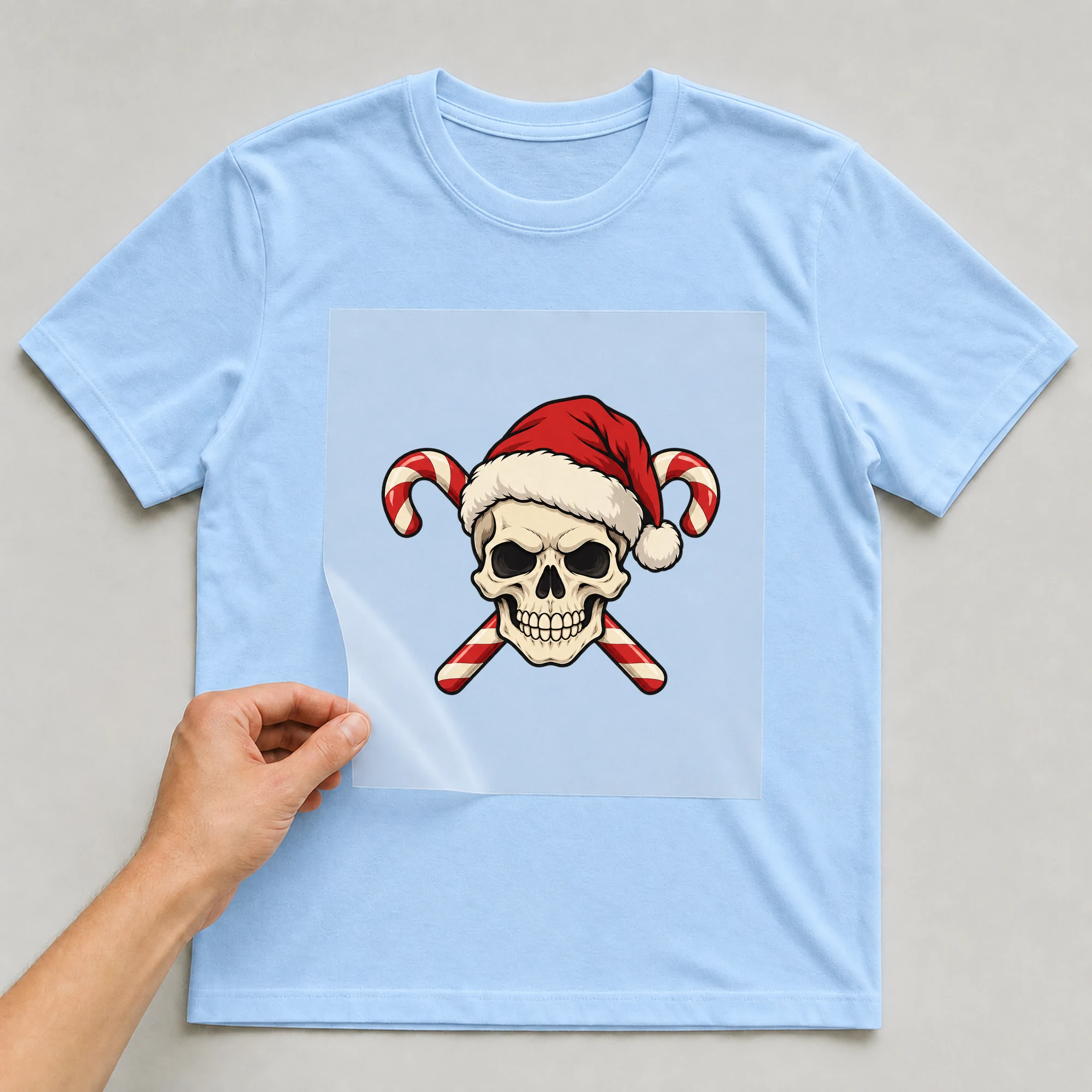 Bügelbild „Weihnachtsschädel“ auf babyblauem T-Shirt, Folie wird aufgelegt