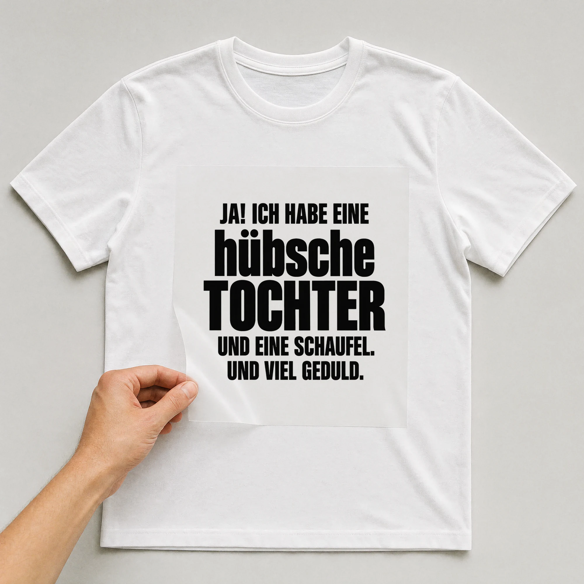 Bügelbild „Ja, ich habe eine hübsche Tochter. Und eine Schaufel. Und viel Geduld.“ auf weißem T-Shirt, Folie wird aufgelegt