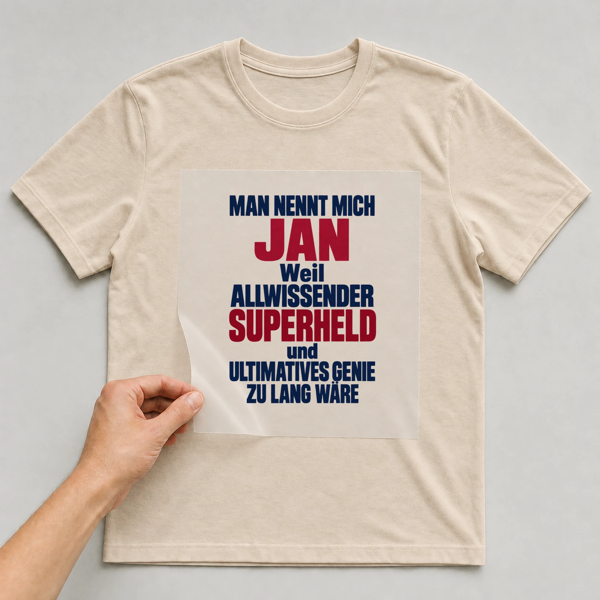 Bügelbild „Man nennt mich Jan weil allwissender Superheld und ultimatives Genie zu lang“ auf babyblauem T-Shirt, Folie wird aufgelegt