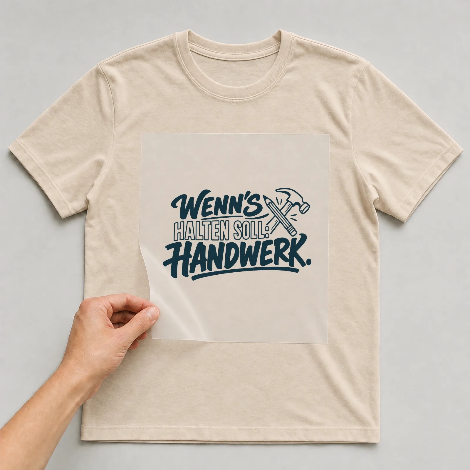 Bügelbild „Wenn's halten soll: Handwerk“ auf beigem T-Shirt, Folie wird aufgelegt