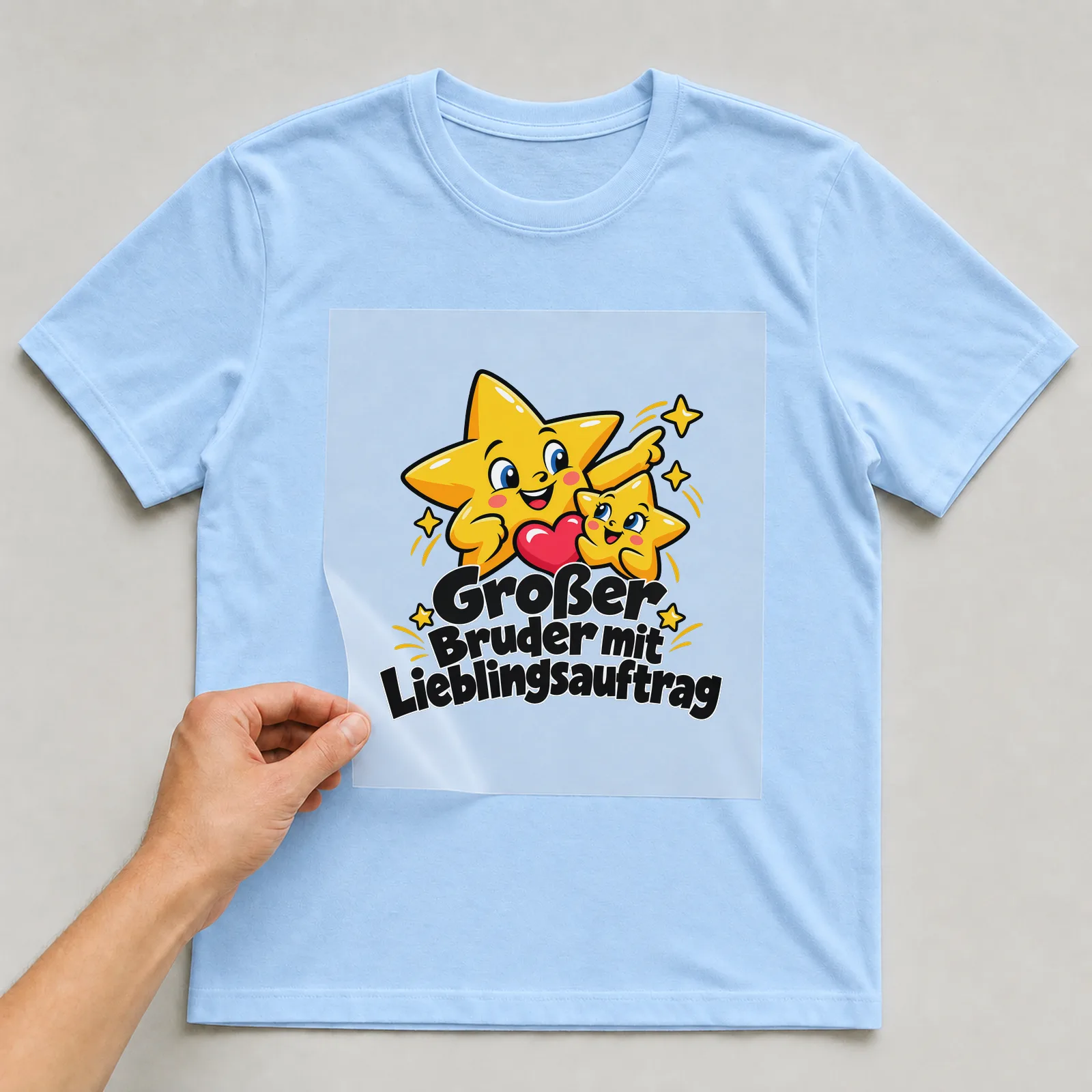 Bügelbild „Großer Bruder mit Lieblingsauftrag“ auf hellblauem T-Shirt, Folie wird aufgelegt