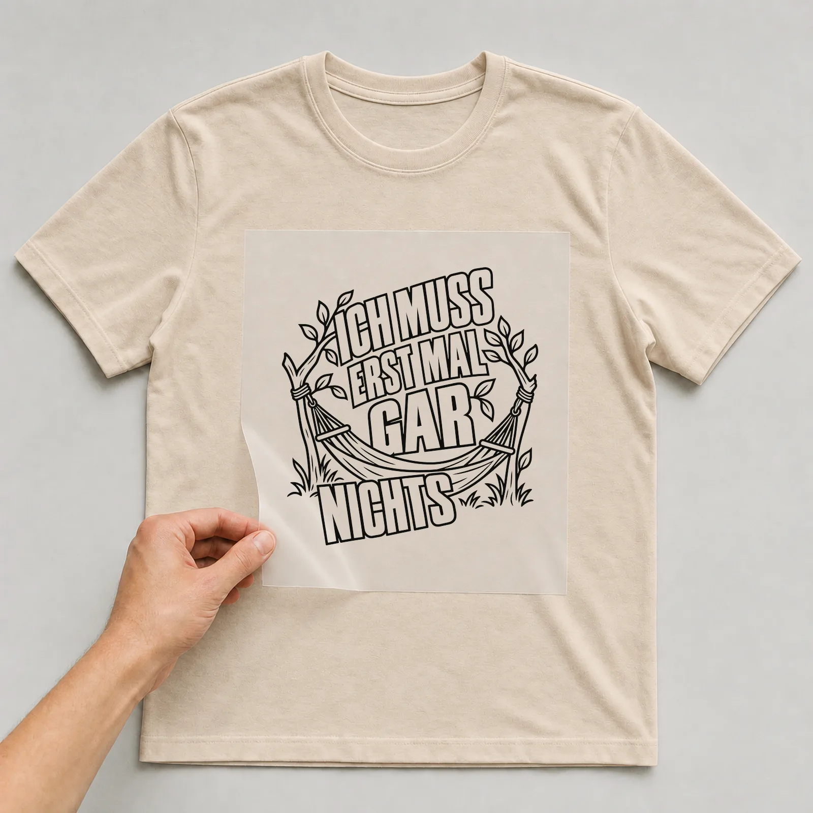 Bügelbild „Ich muss erst mal gar nichts“ auf beigem T-Shirt, Folie wird aufgelegt