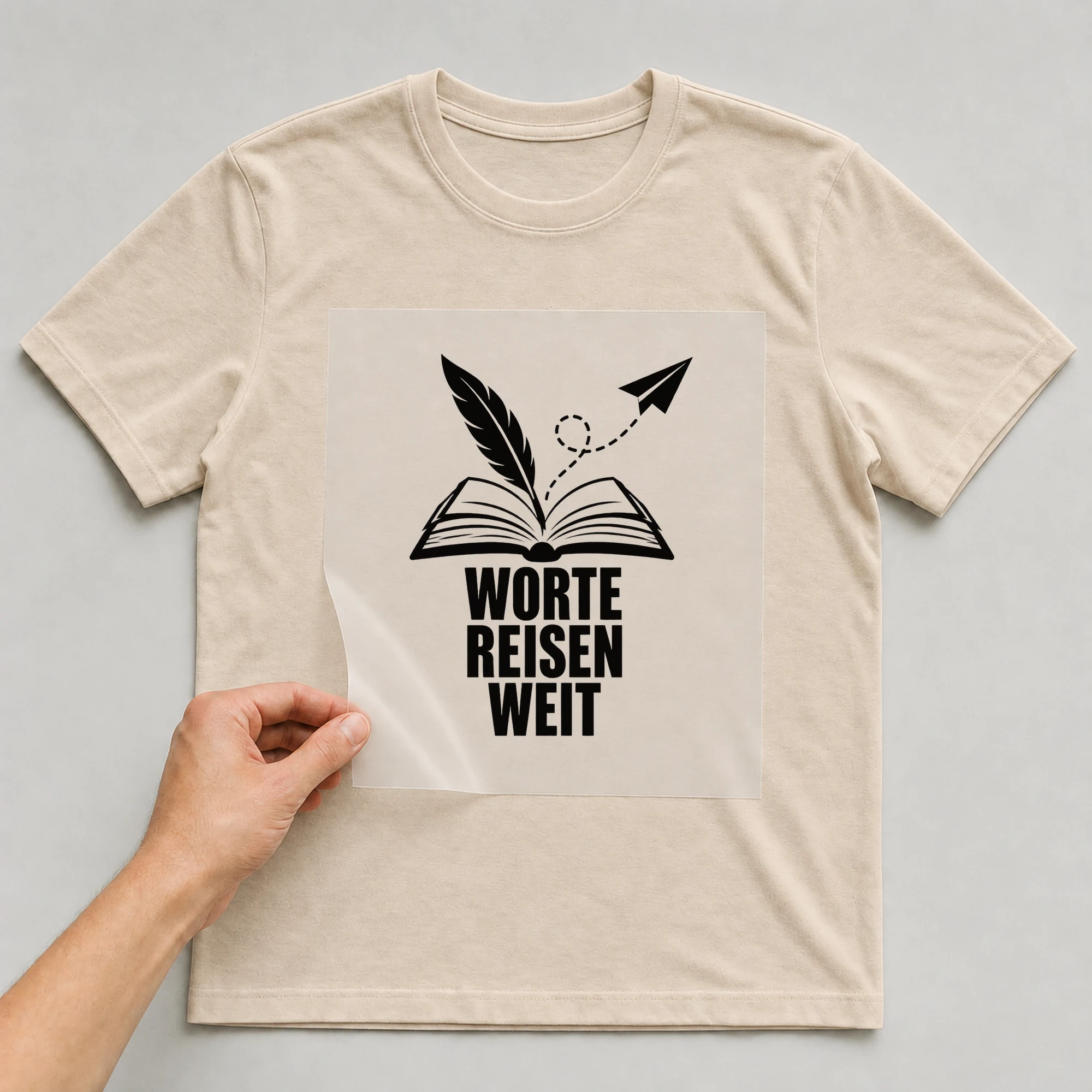 Bügelbild „Ich mach Worte weit“ auf beigem T-Shirt, Folie wird aufgelegt