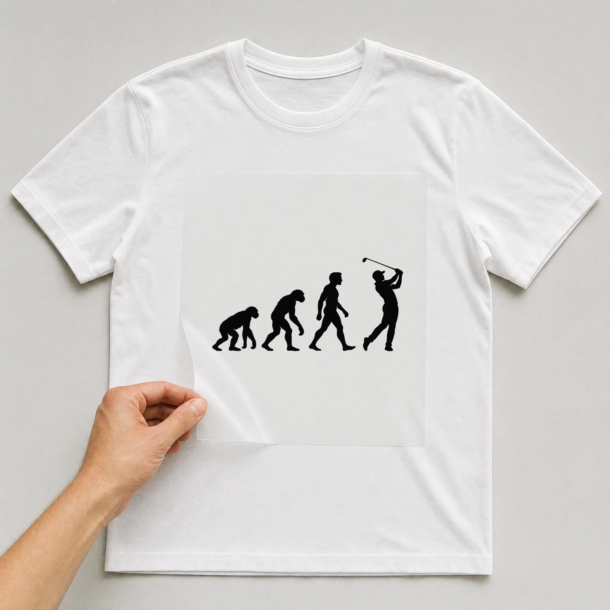 Bügelbild „Evolution des Golfes“ auf weißem T-Shirt, Folie wird aufgelegt