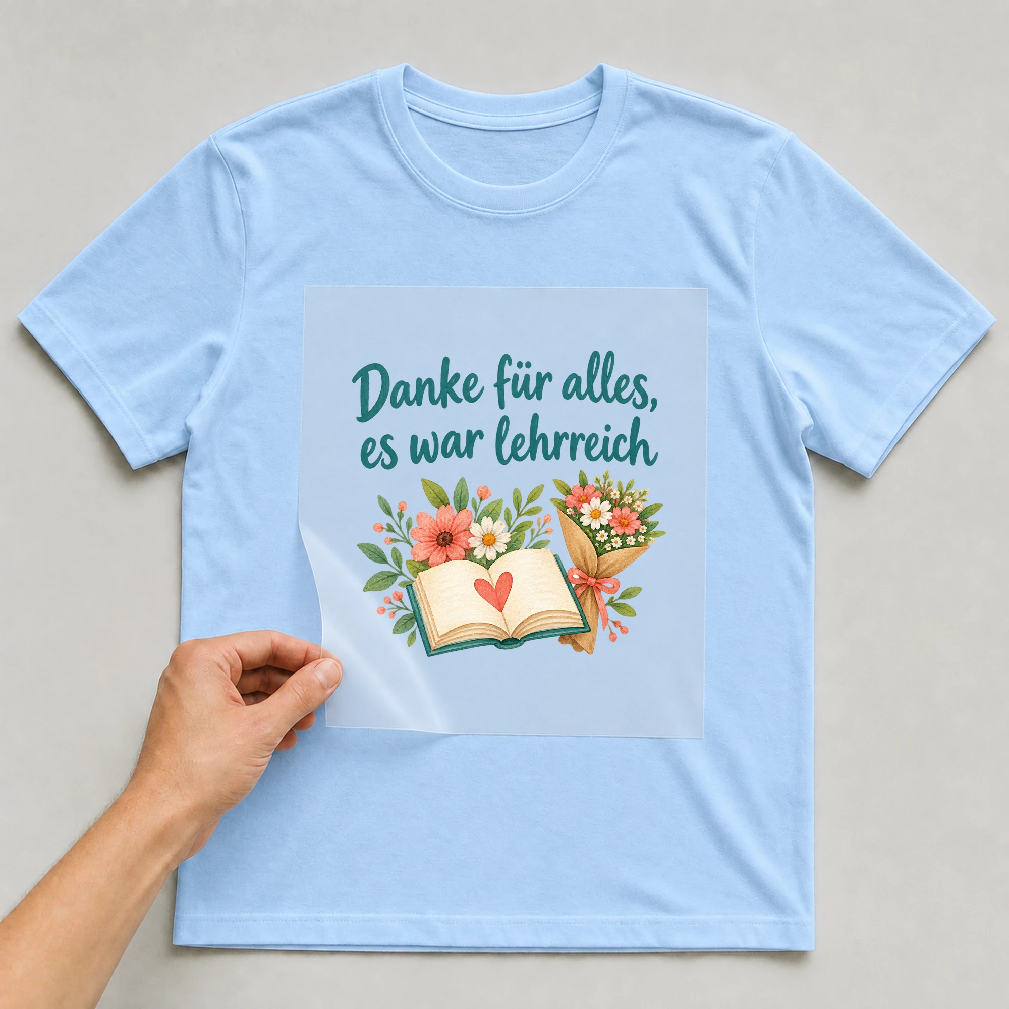 Bügelbild „Danke für alles, es war lehrreich“ auf babyblauem T-Shirt, Folie wird aufgelegt