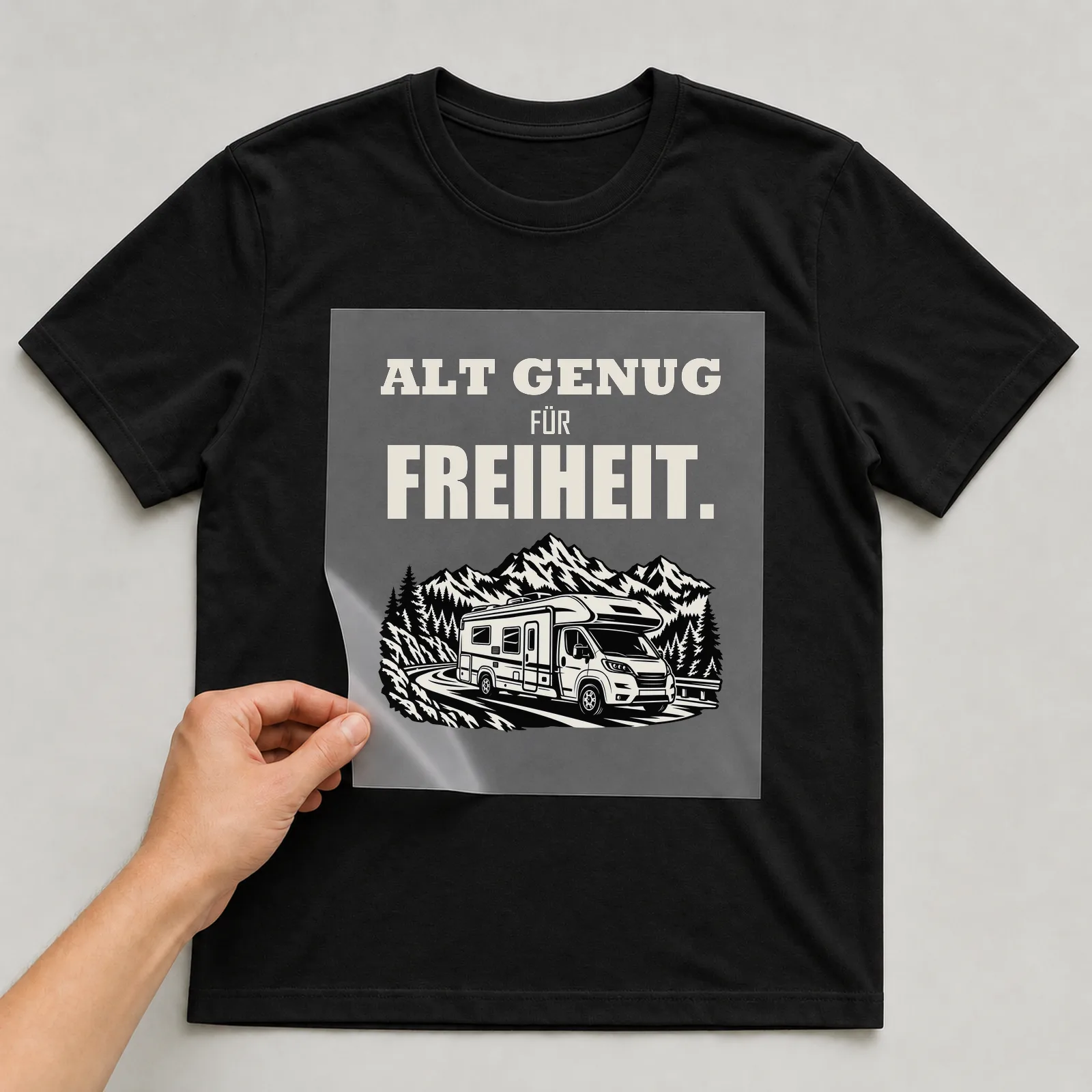 Bügelbild „Alt genug für Freiheit“ auf schwarzem T-Shirt, Folie wird aufgelegt