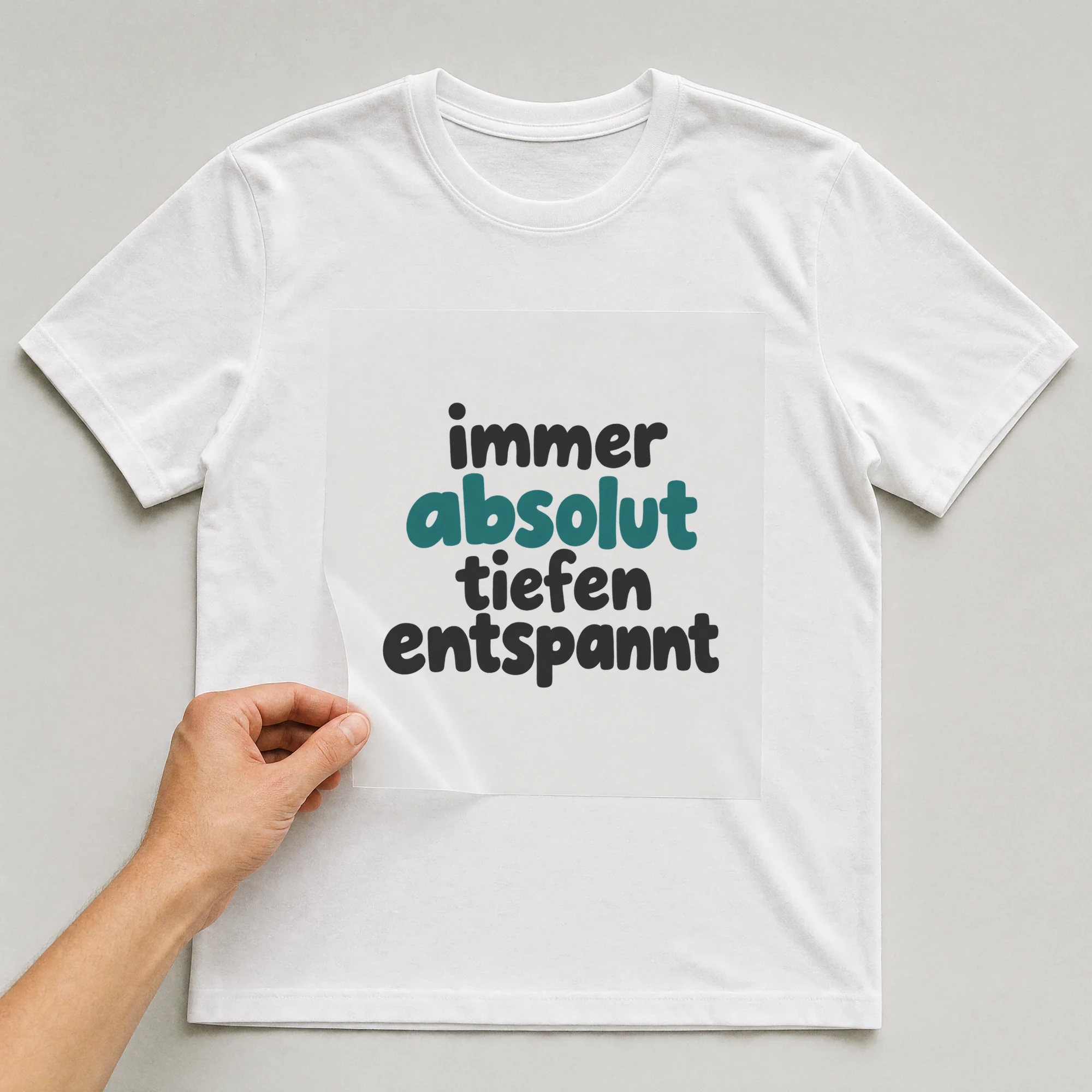 Bügelbild „immer absolut tiefen entspannt“ auf weißem T-Shirt, Folie wird aufgelegt