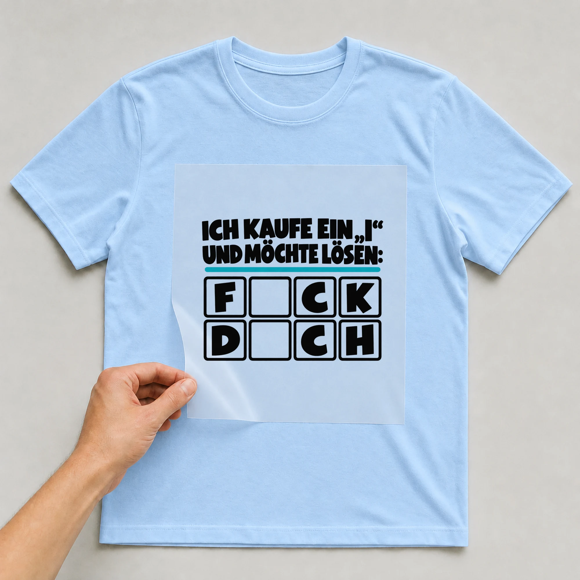 Bügelbild „Ich kaufe ein „i“ auf babyblauem T-Shirt, Folie wird aufgelegt