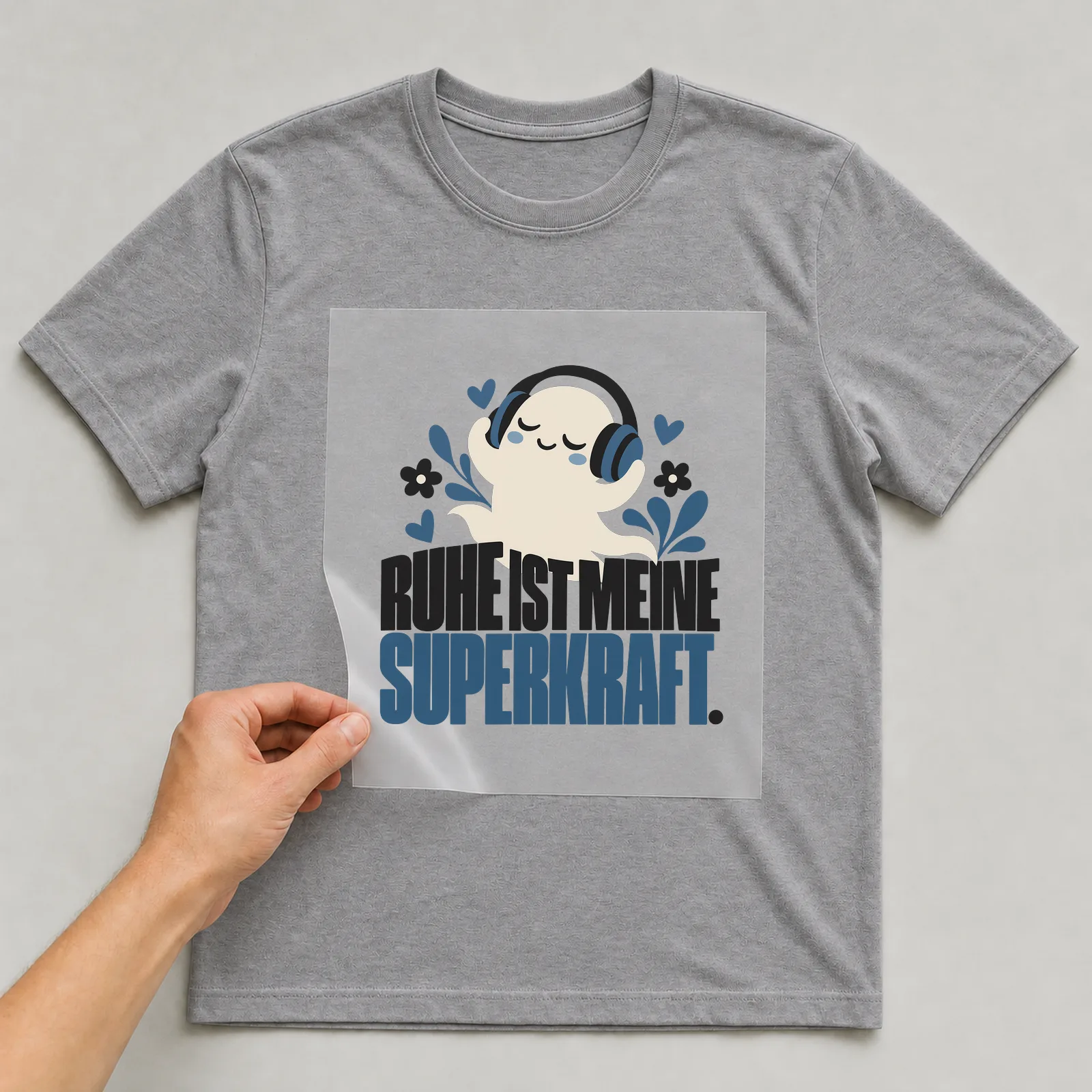 Bügelbild „Ruhe ist meine Superkraft“ auf grauem T-Shirt, Folie wird aufgelegt