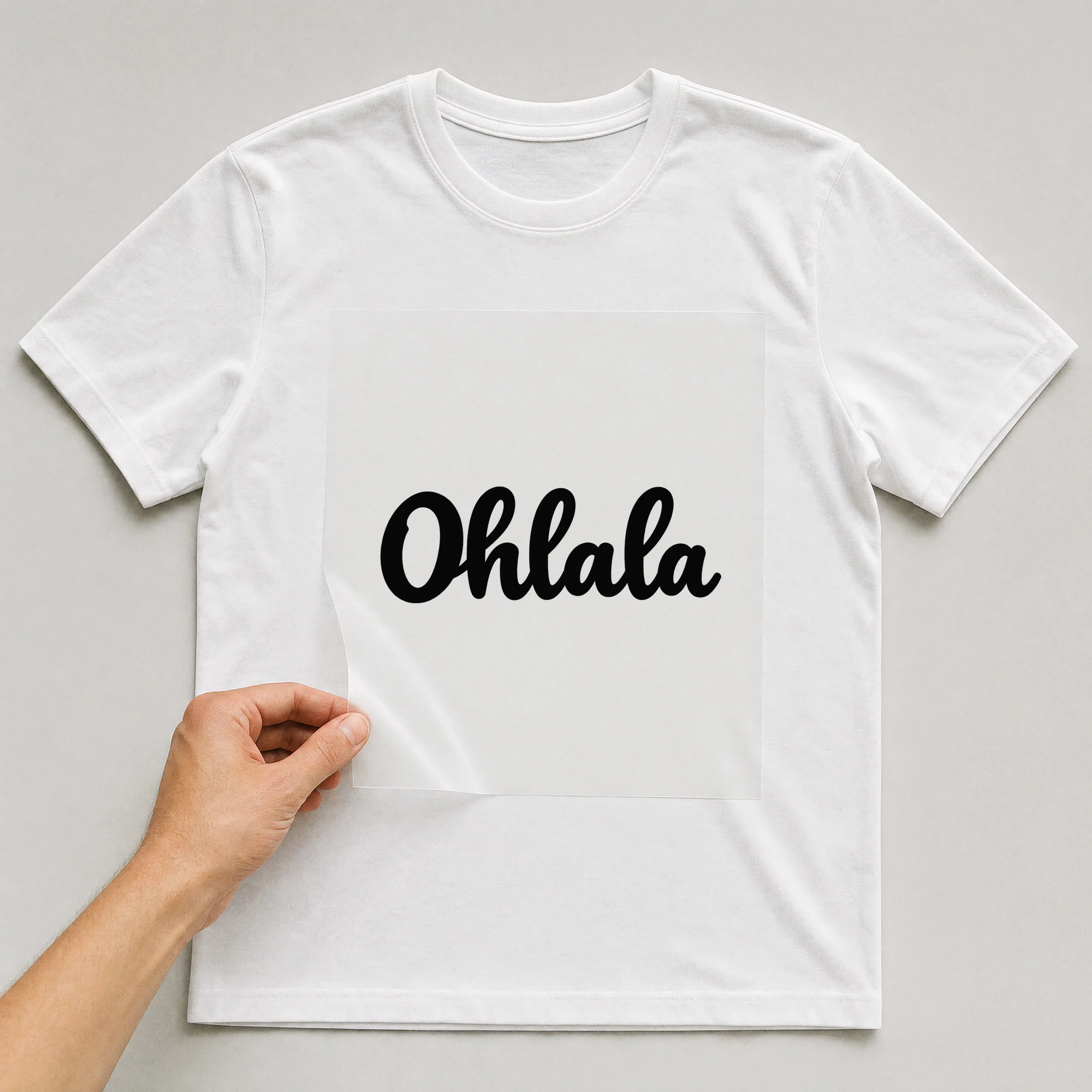 Bügelbild „Ohlala“ auf weißem T-Shirt, Folie wird aufgelegt