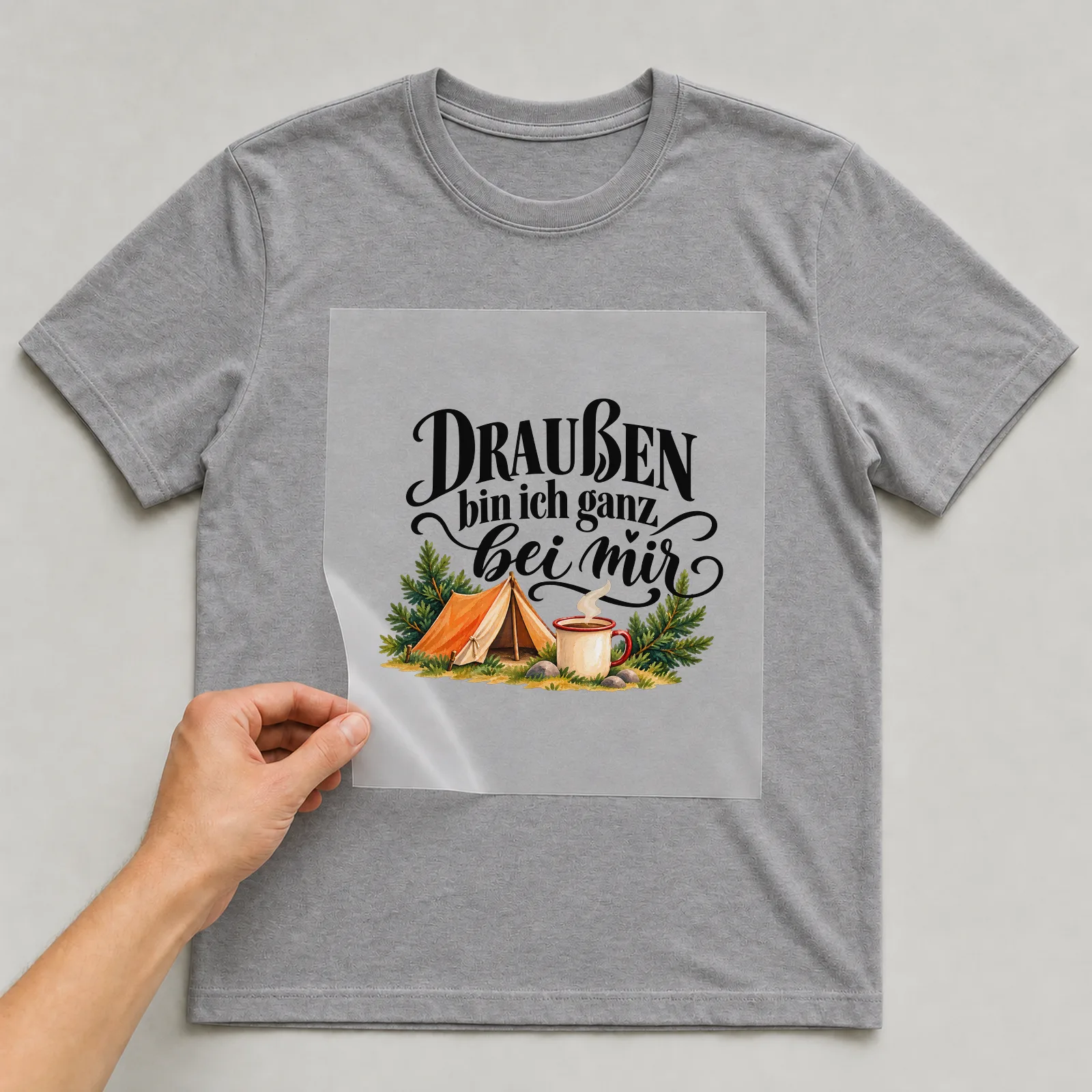 Bügelbild „Draußen bin ich ganz bei mir“ auf grauem T-Shirt, Folie wird aufgelegt