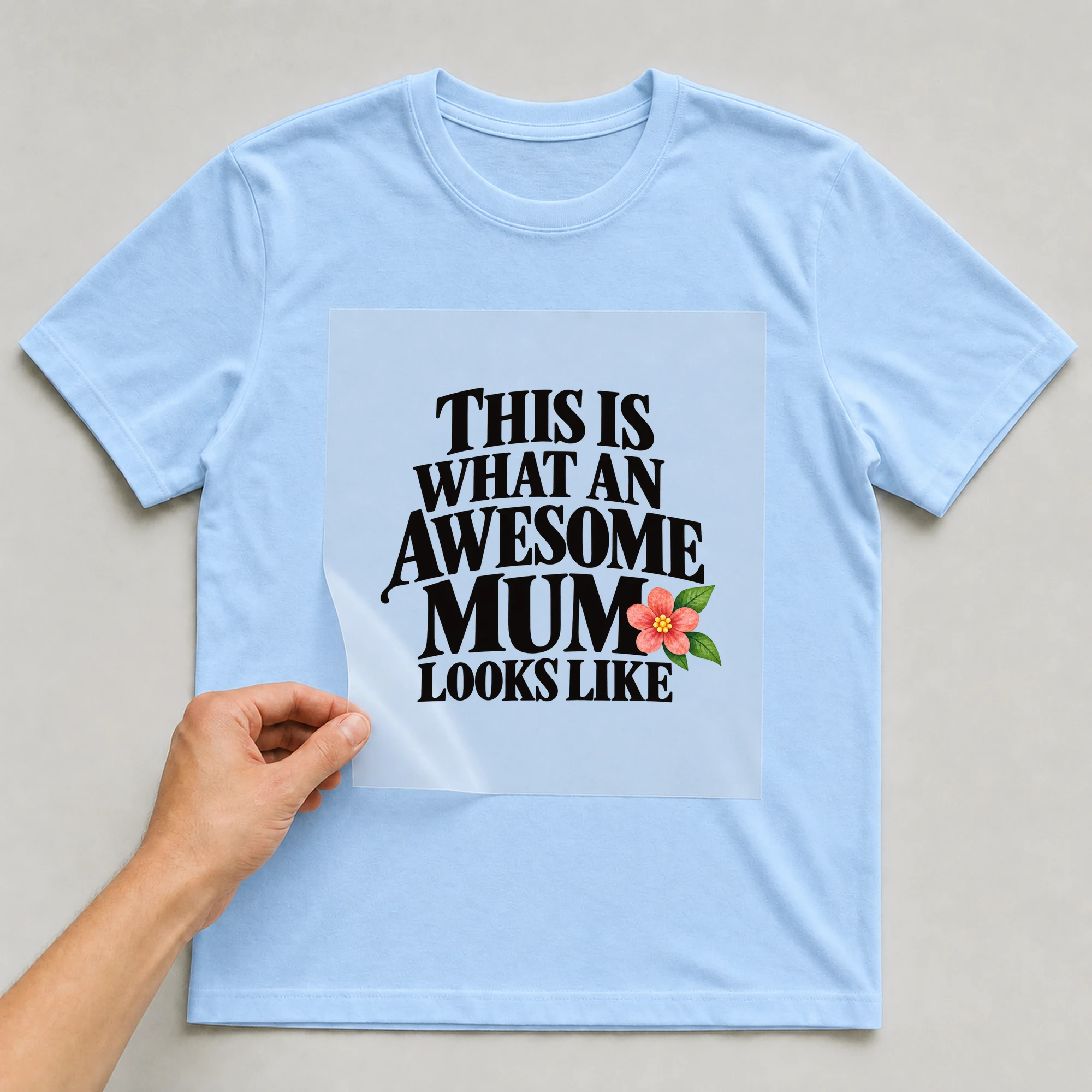 Bügelbild „This Is What An Awesome Mum Looks Like“ auf babyblauem T-Shirt, Folie wird aufgelegt