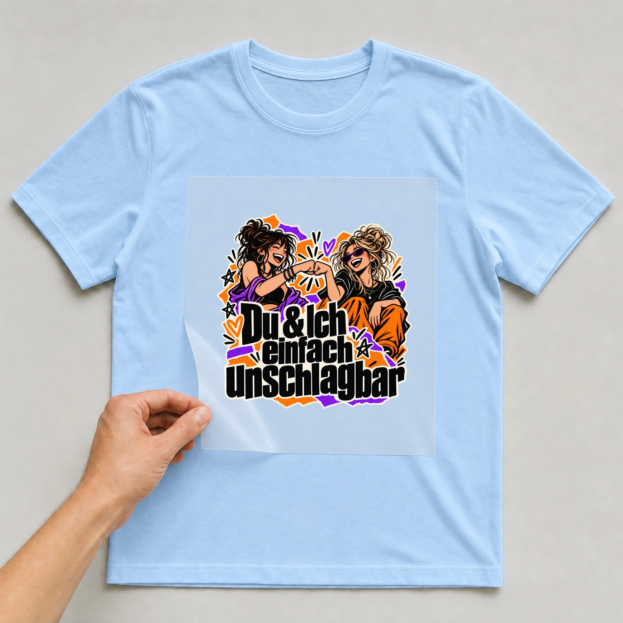 Bügelbild „Du & Ich einfach unschlagbar“ auf babyblauem T-Shirt, Folie wird aufgelegt