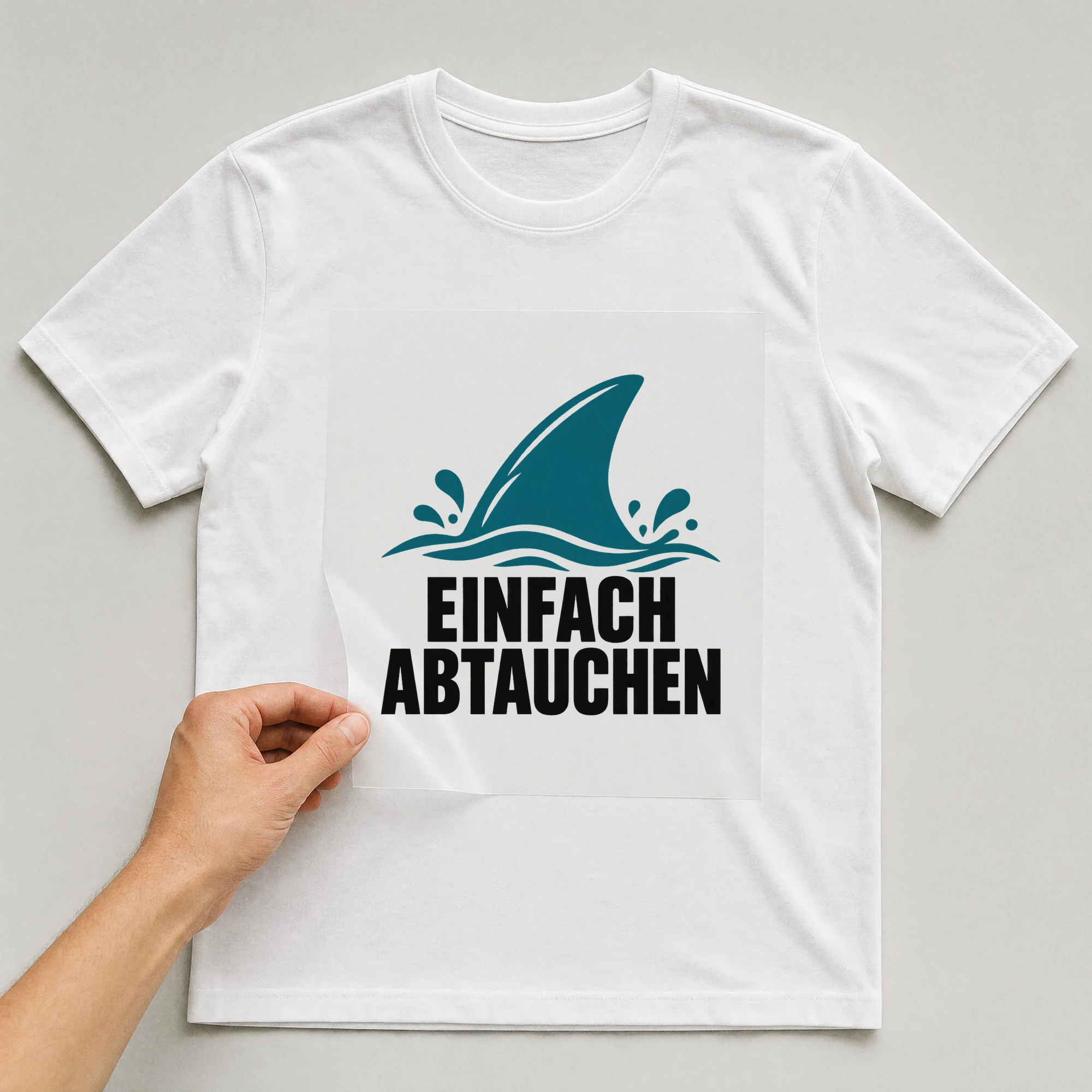 Bügelbild „Einfach abtauchen“ auf weißem T-Shirt, Folie wird aufgelegt