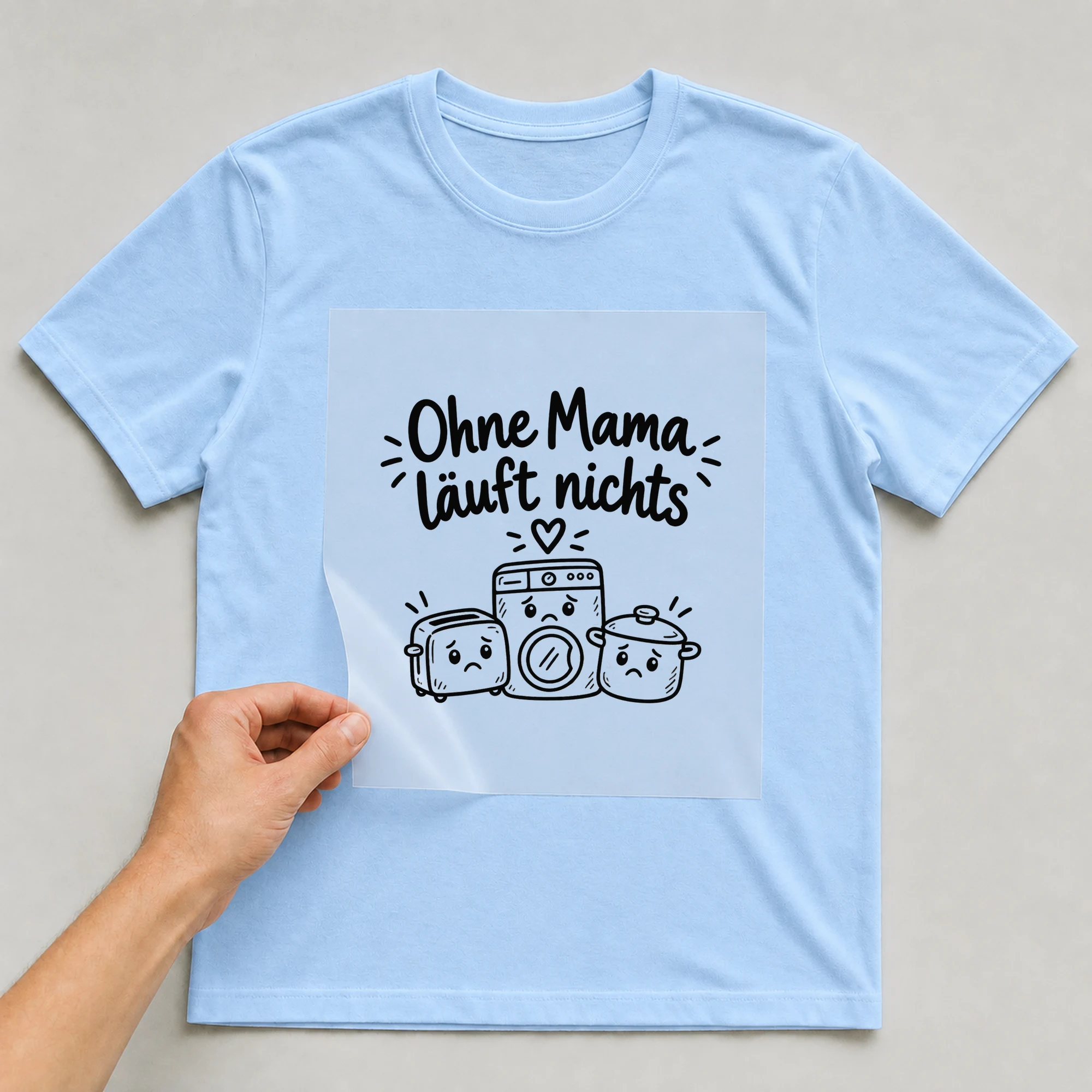 Bügelbild „Ohne Mama läuft nichts“ auf babyblauem T-Shirt, Folie wird aufgelegt