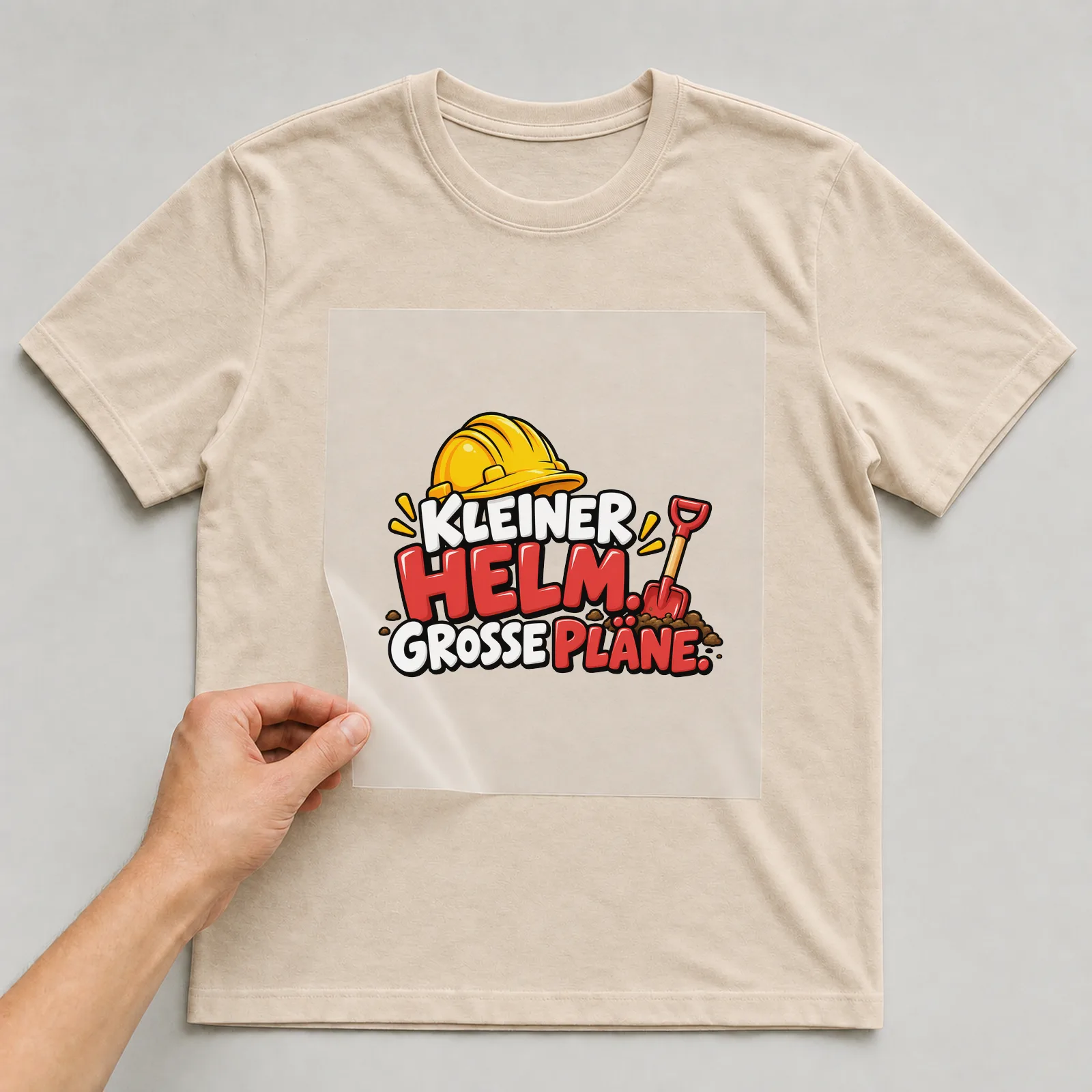 Bügelbild „Kleiner Helm. Große Pläne.“ auf beigem T-Shirt, Folie wird aufgelegt