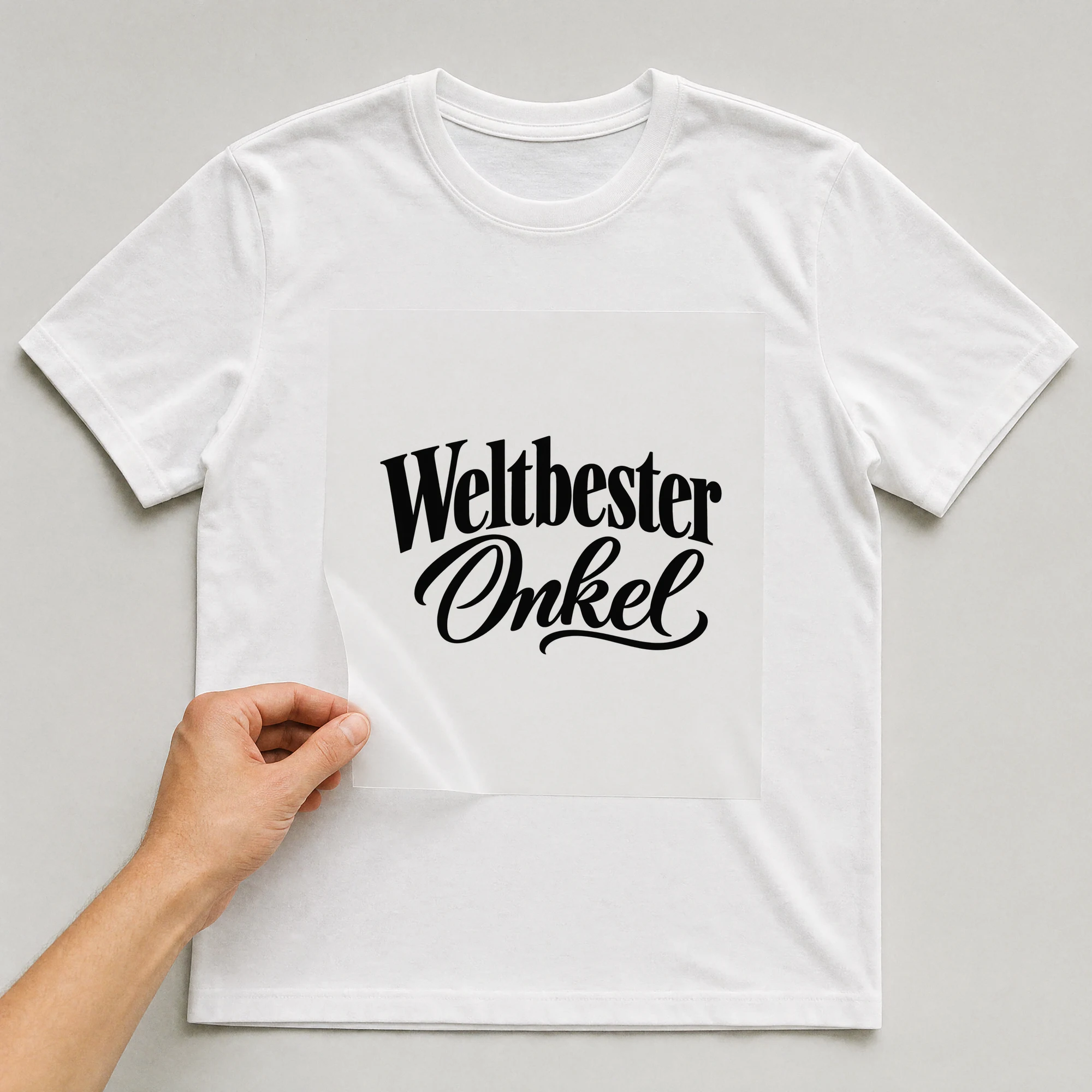 Bügelbild „Weltbester Onkel“ auf weißem T-Shirt, Folie wird aufgelegt