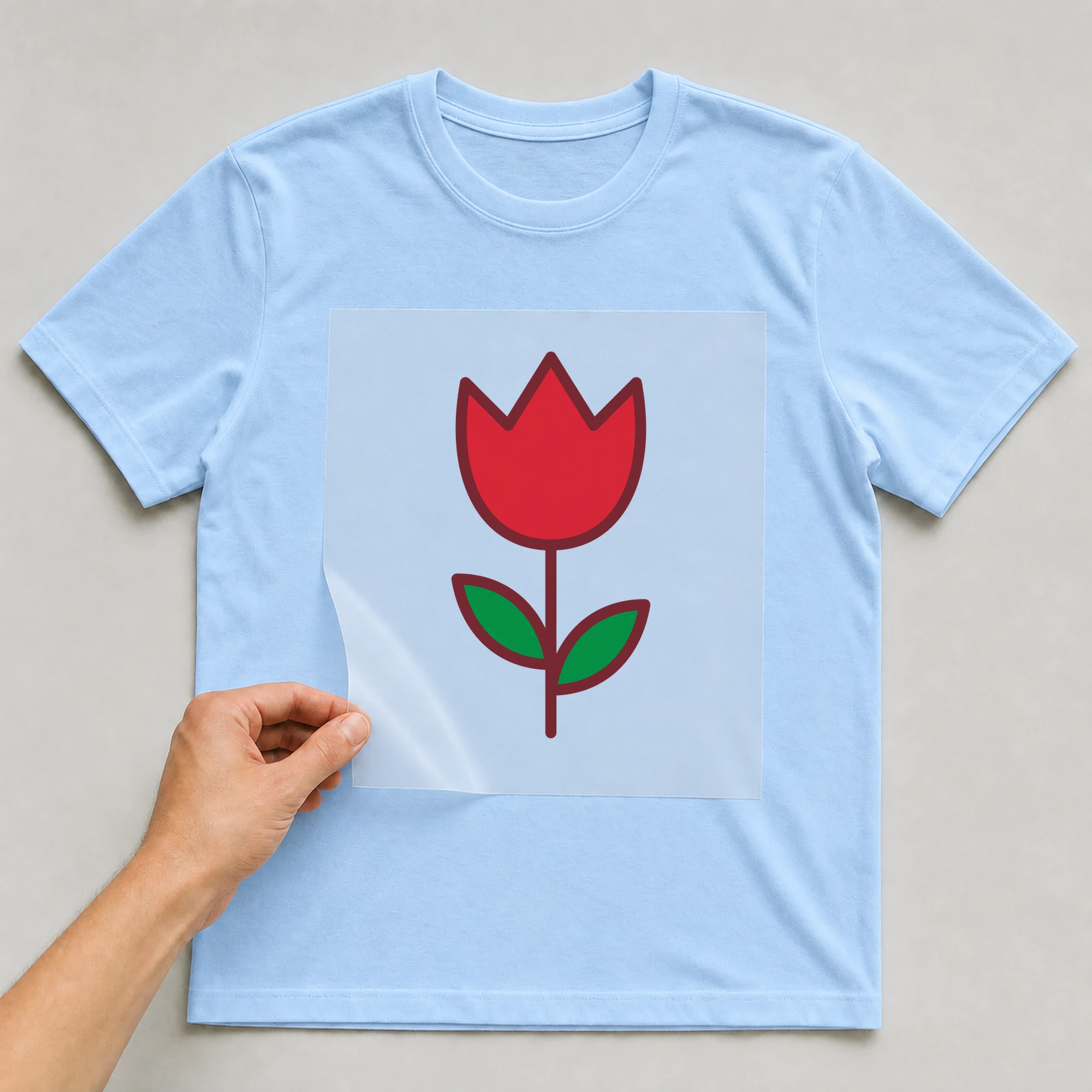 Bügelbild „Tulpe“ auf babyblauem T-Shirt, Folie wird aufgelegt