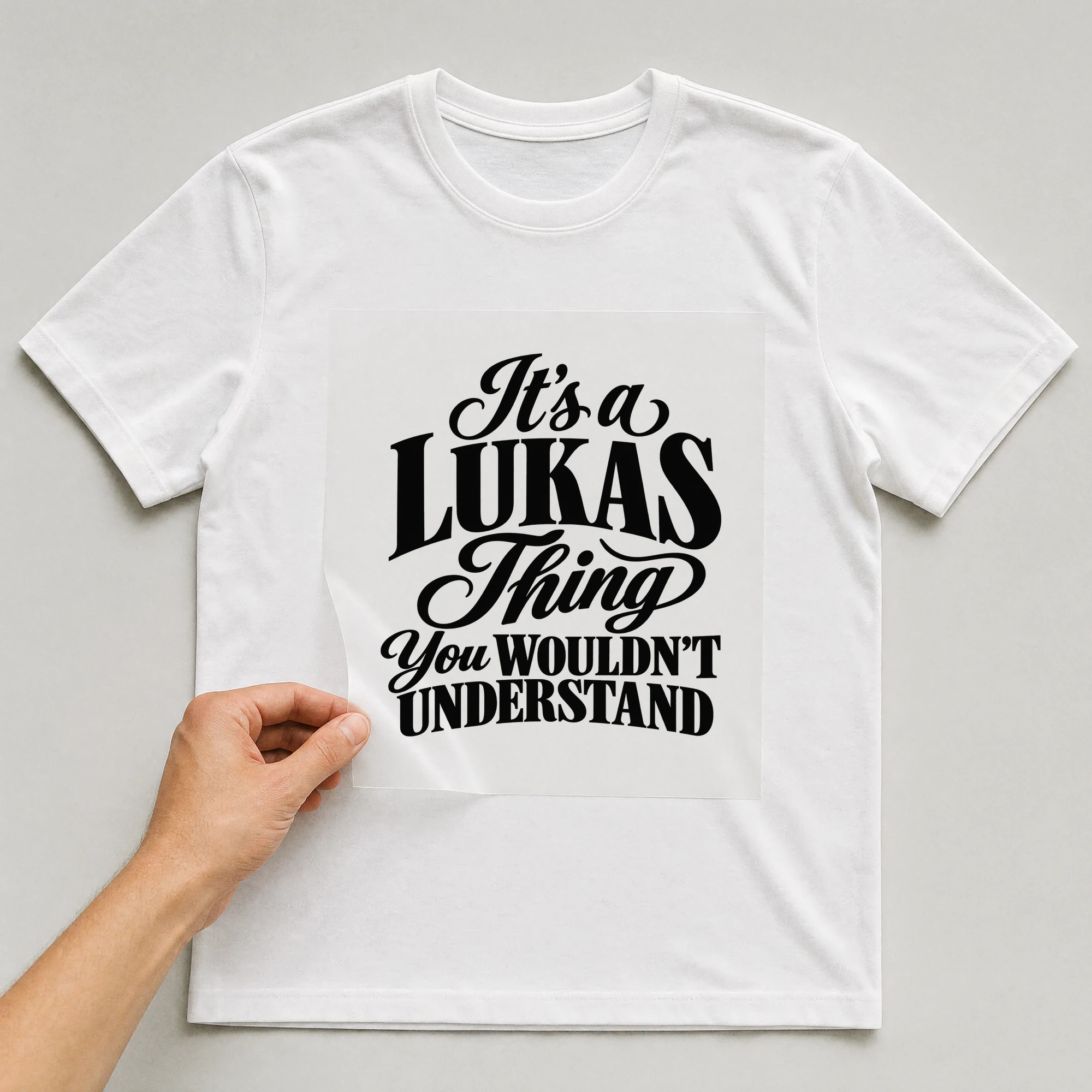 Bügelbild „It's a LUKAS Thing You WOULDN'T UNDERSTAND“ auf weißem T-Shirt, Folie wird aufgelegt