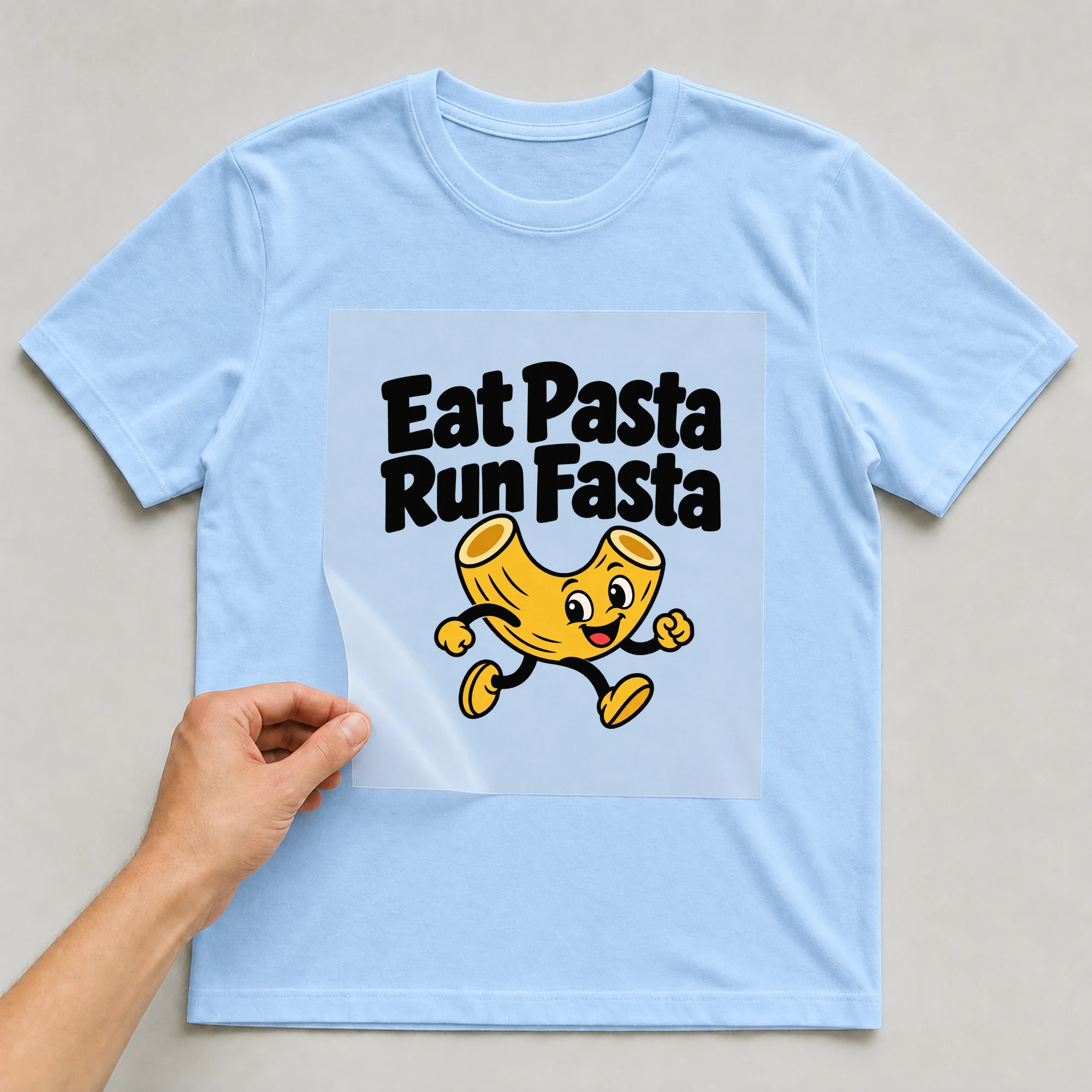Bügelbild „Eat Pasta Run Fasta“ auf babyblauem T-Shirt, Folie wird aufgelegt