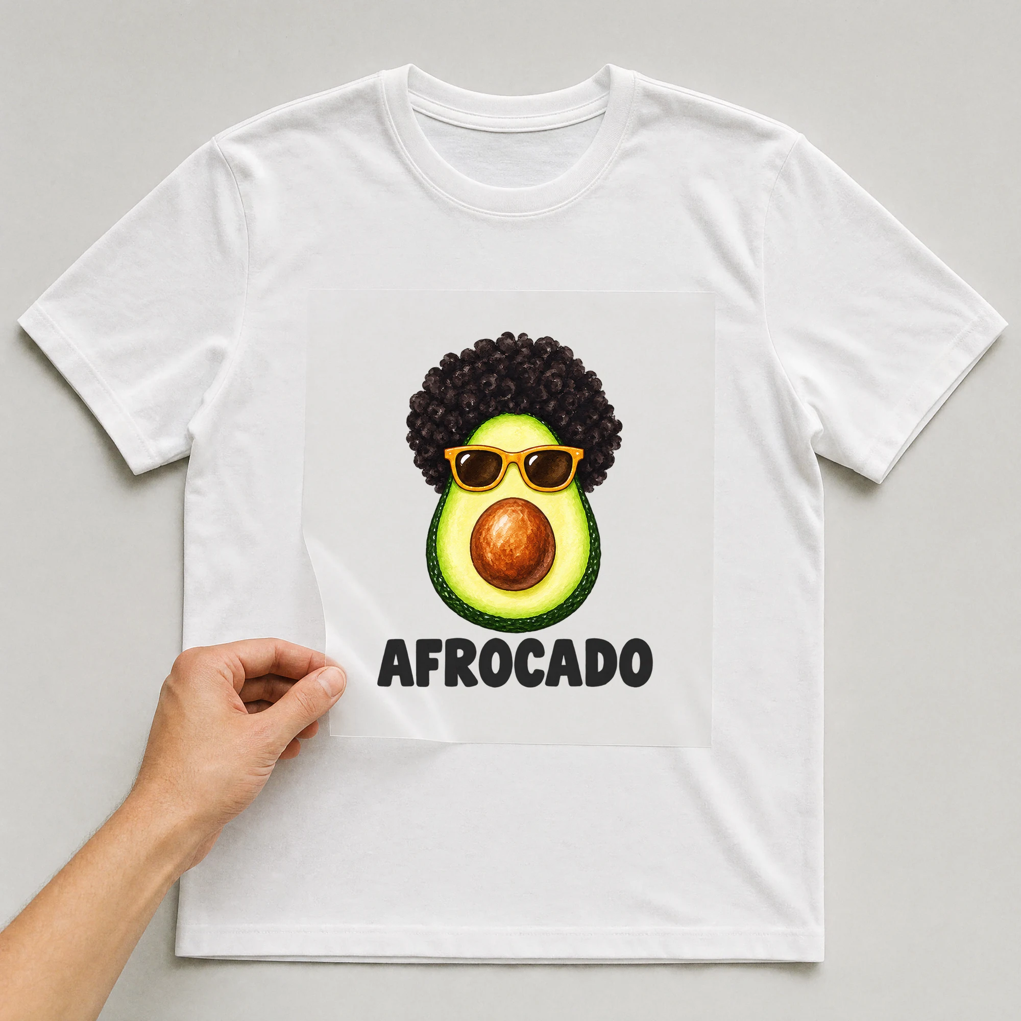 Bügelbild „Afrocado“ auf weißem T-Shirt, Folie wird aufgelegt