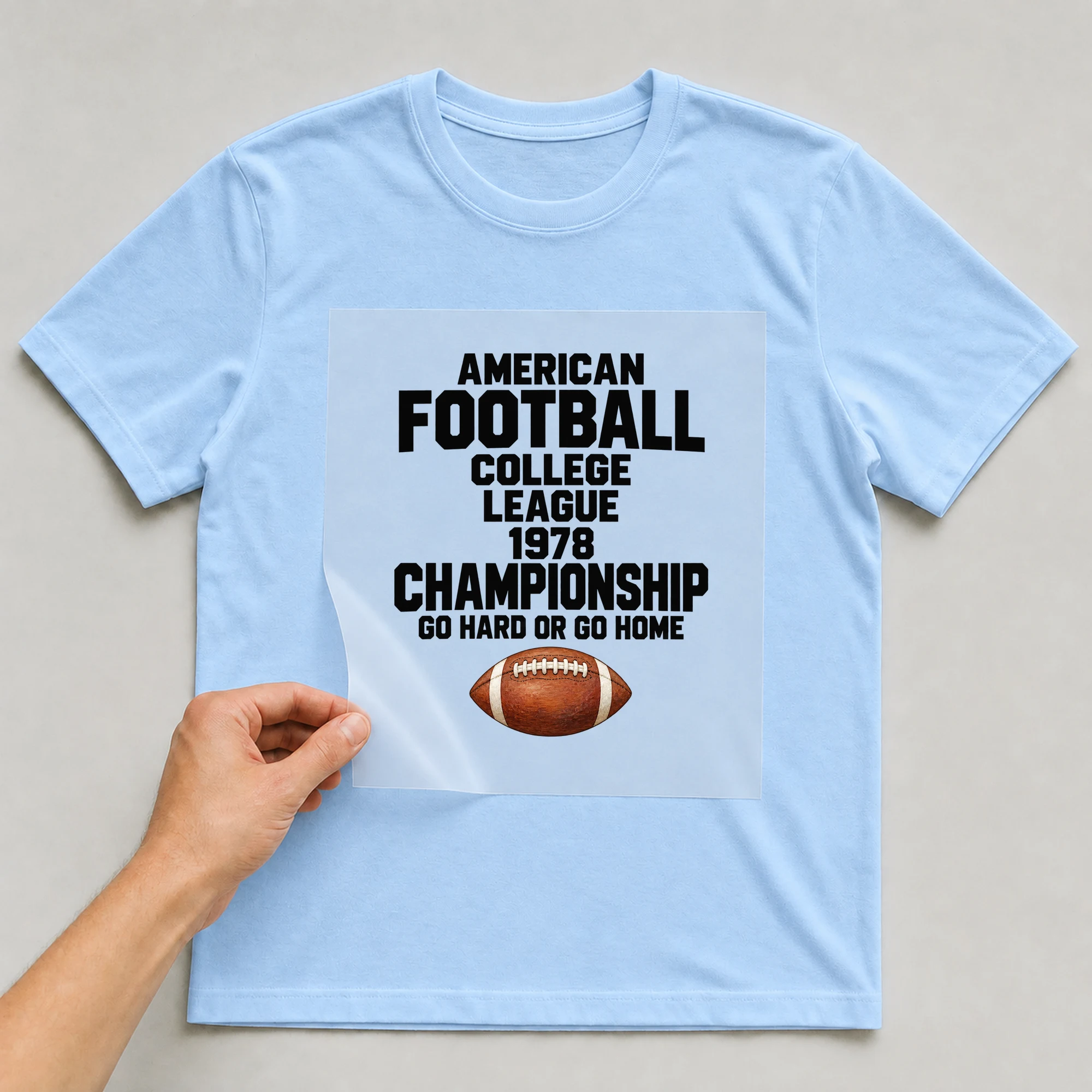 Bügelbild „American Football College League 1978 Championship Go Hard Or Go Home“ auf babyblauem T-Shirt, Folie wird aufgelegt