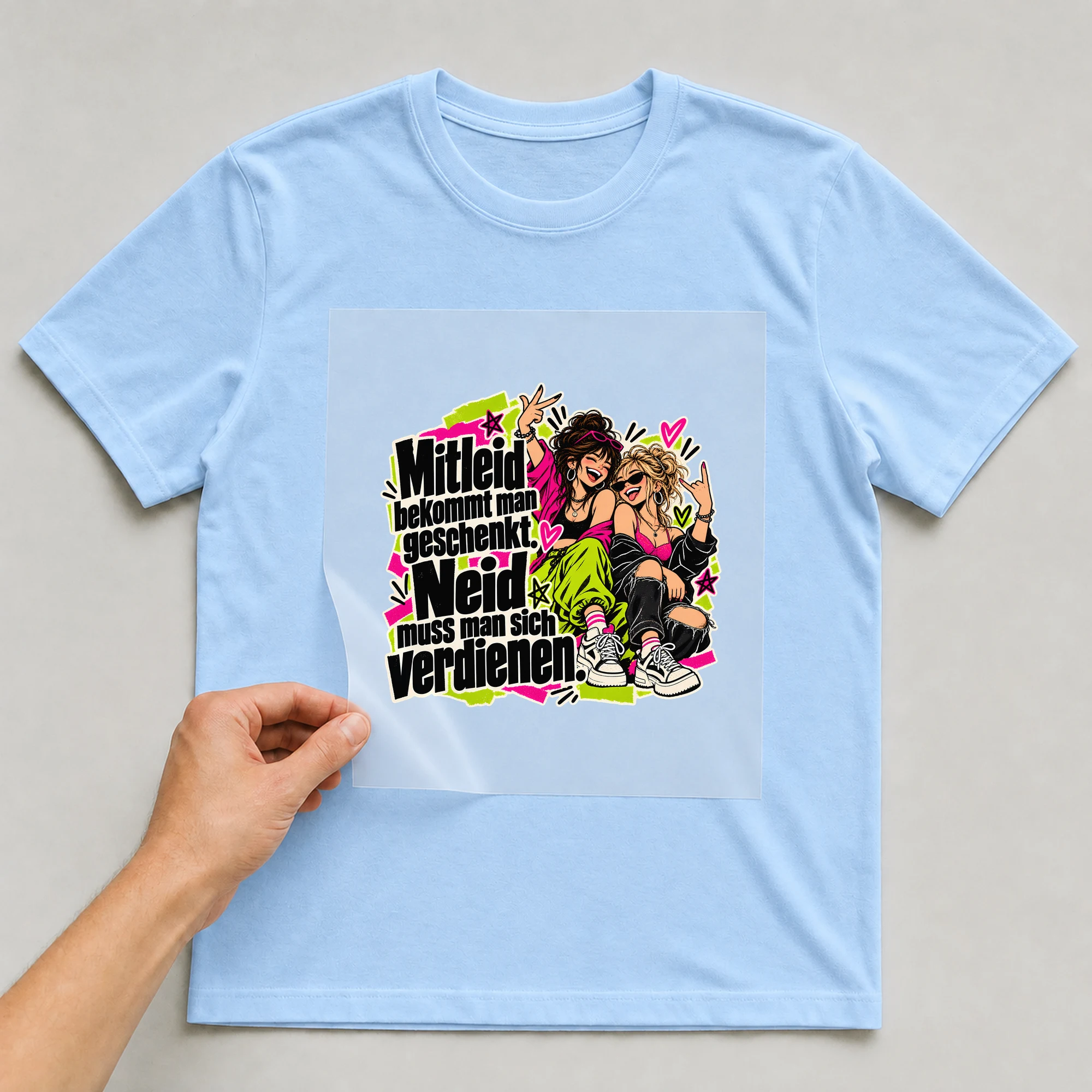 Bügelbild „Mitleid bekommt man geschenkt.“ auf babyblauem T-Shirt, Folie wird aufgelegt