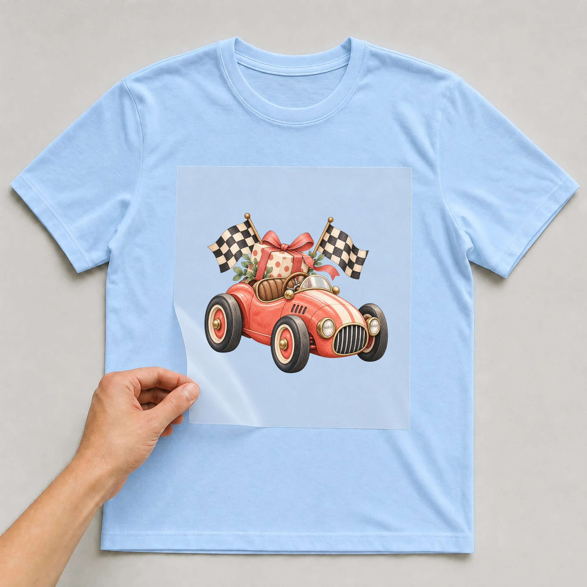 Bügelbild „Rennwagen zum Geburtstag“ auf babyblauem T-Shirt, Folie wird aufgelegt