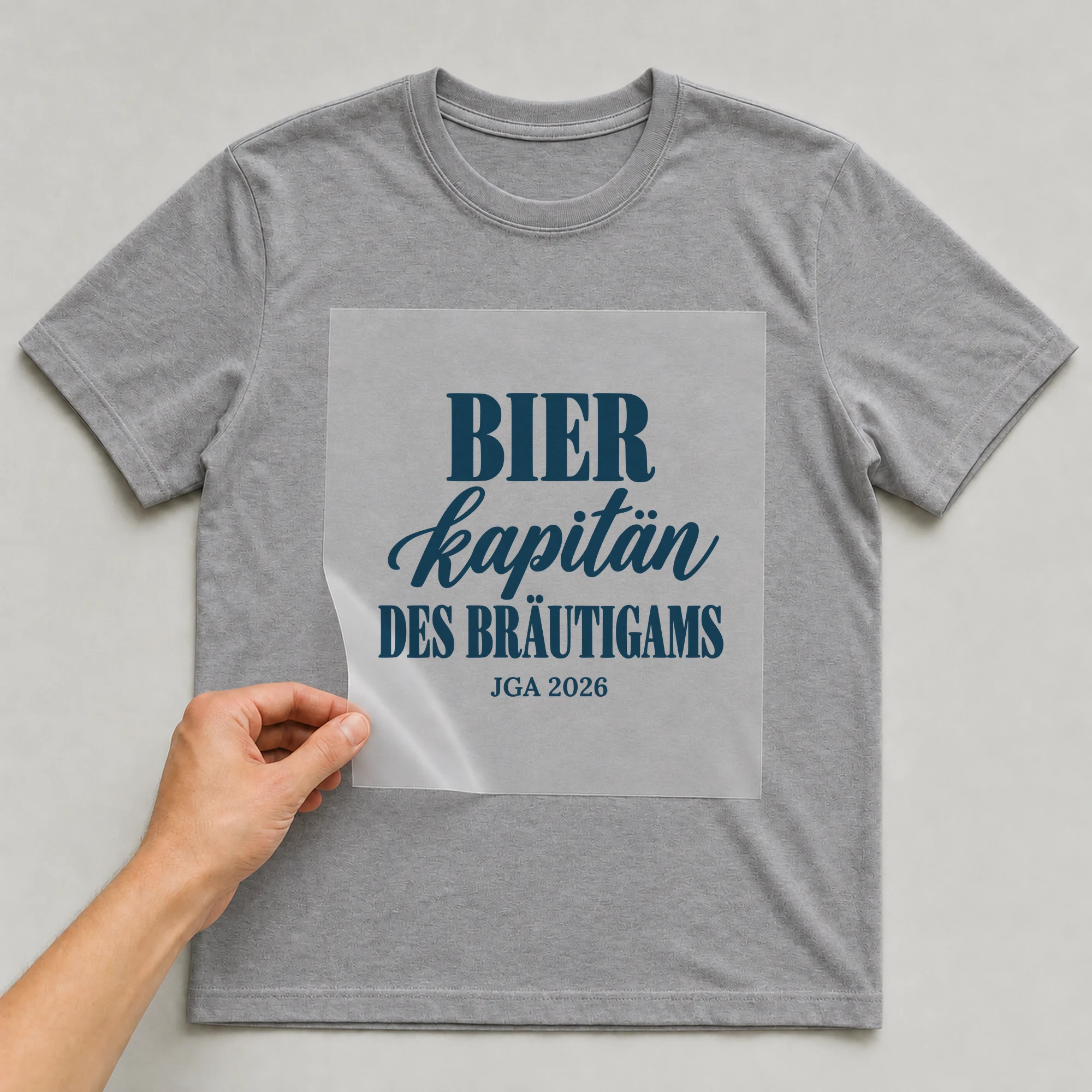 Bügelbild Bierkapitän des Bräutigams mit Jahr auf grauem T-Shirt, Folie wird aufgelegt