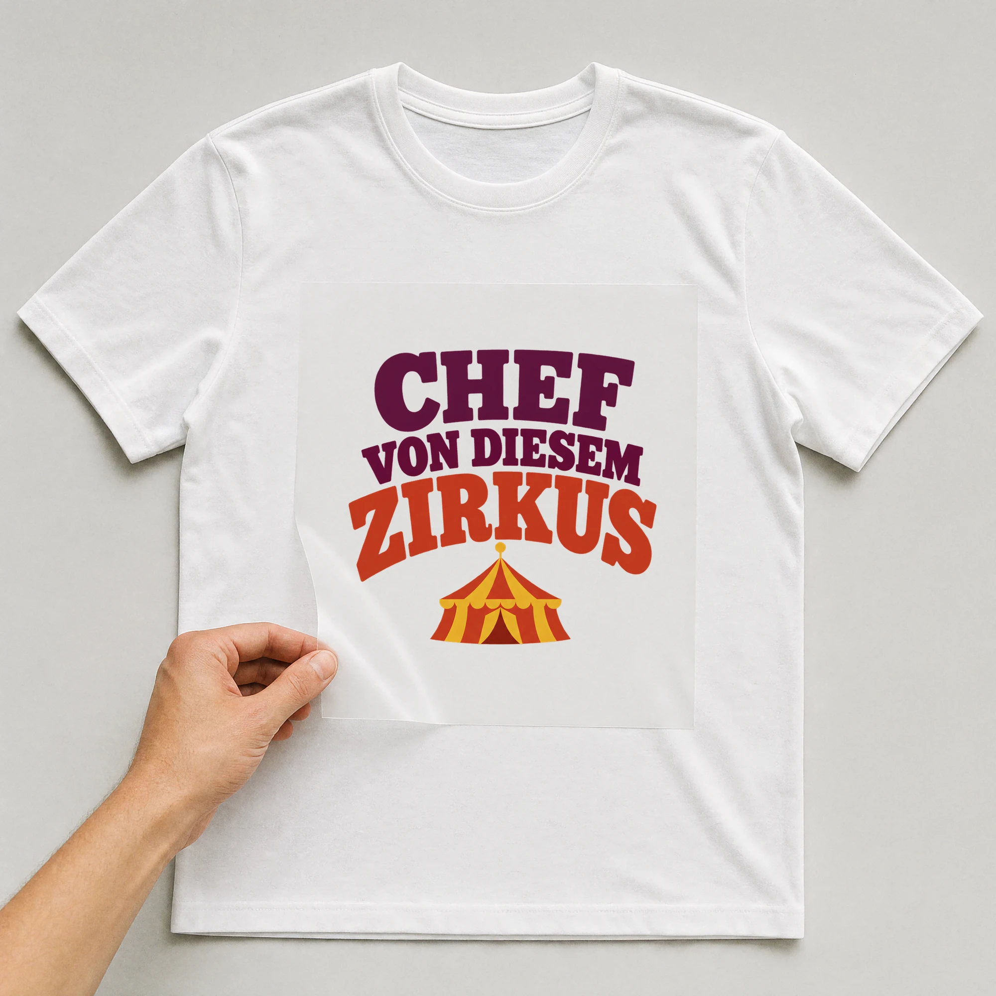 Bügelbild „Chef von diesem Zirkus“ auf weißem T-Shirt, Folie wird aufgelegt