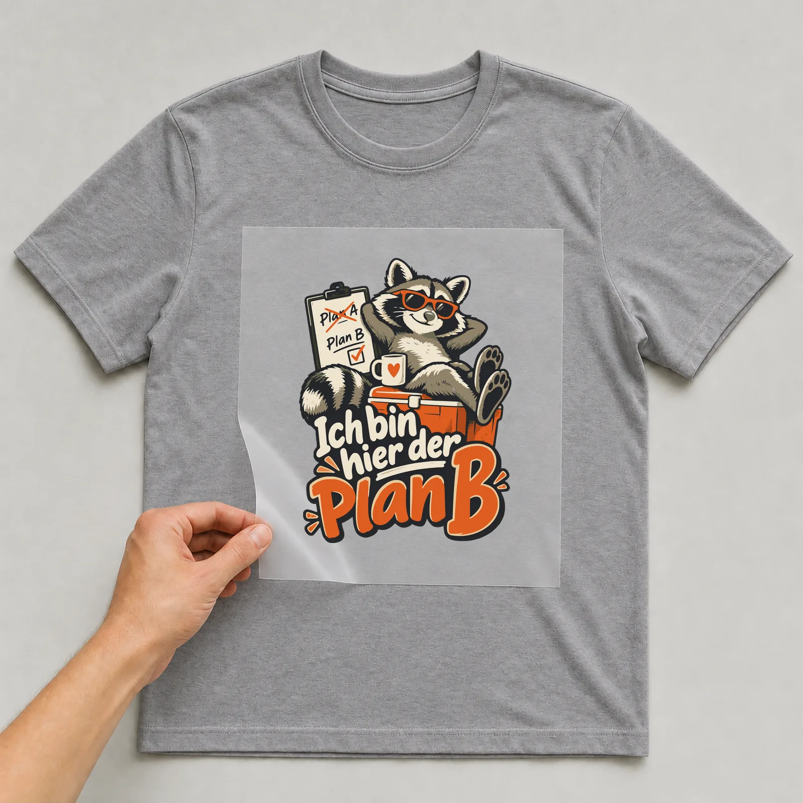 Bügelbild Ich bin hier der Plan B auf grauem T-Shirt, Folie wird aufgelegt