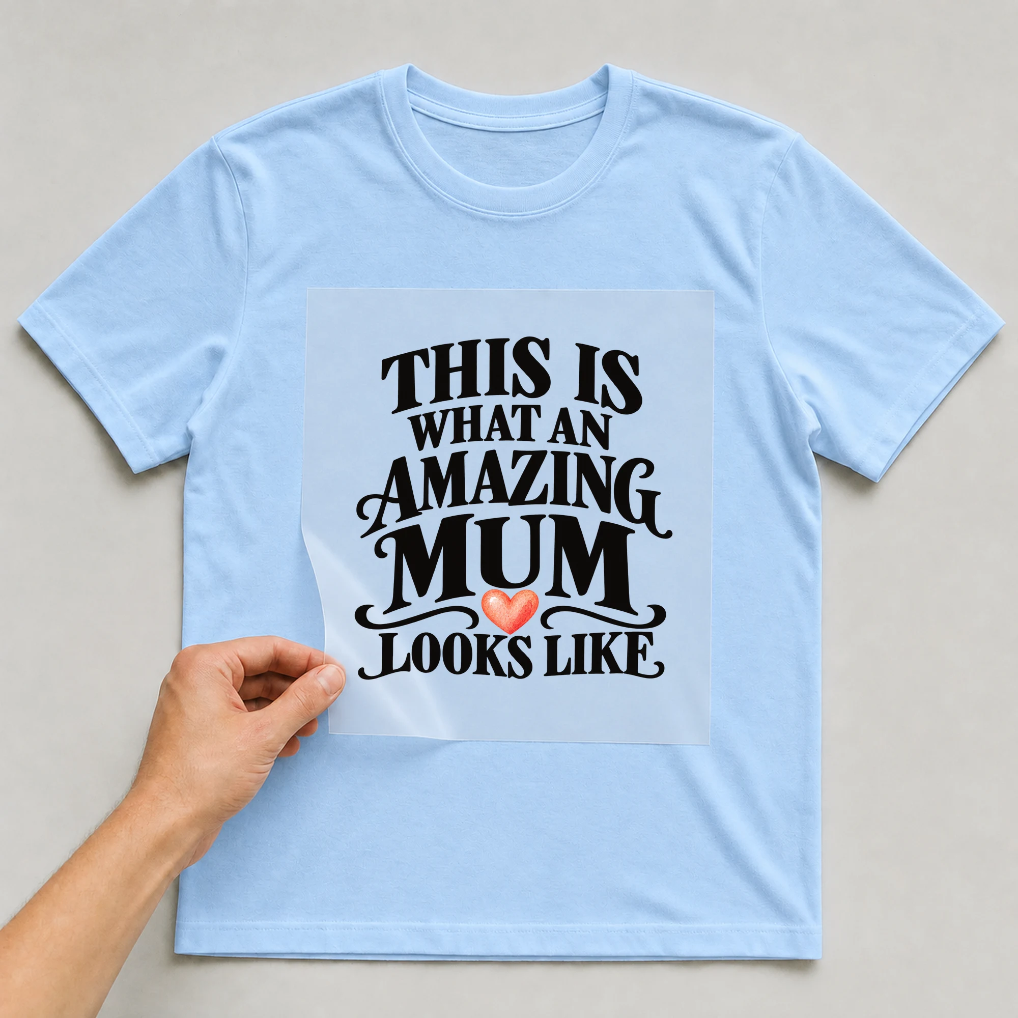 Bügelbild „This Is What An Amazing Mum Looks Like“ auf babyblauem T-Shirt, Folie wird aufgelegt