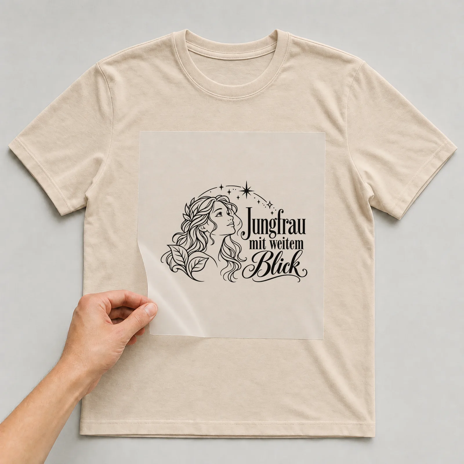 Bügelbild „Jungfrau mit weitem Blick“ auf beigem T-Shirt, Folie wird aufgelegt