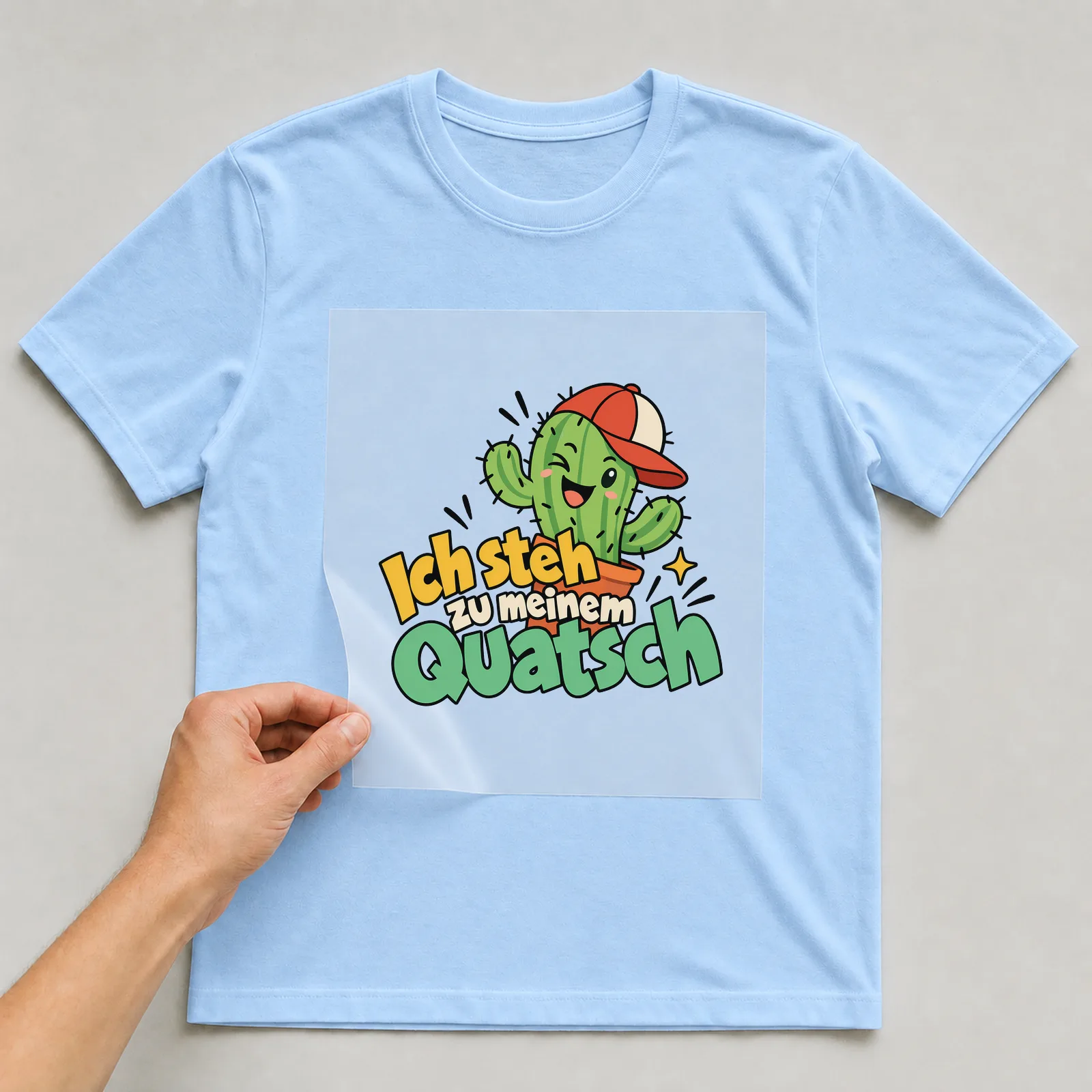 Bügelbild „Ich steh zu meinem Quatsch“ auf hellblauem T-Shirt, Folie wird aufgelegt