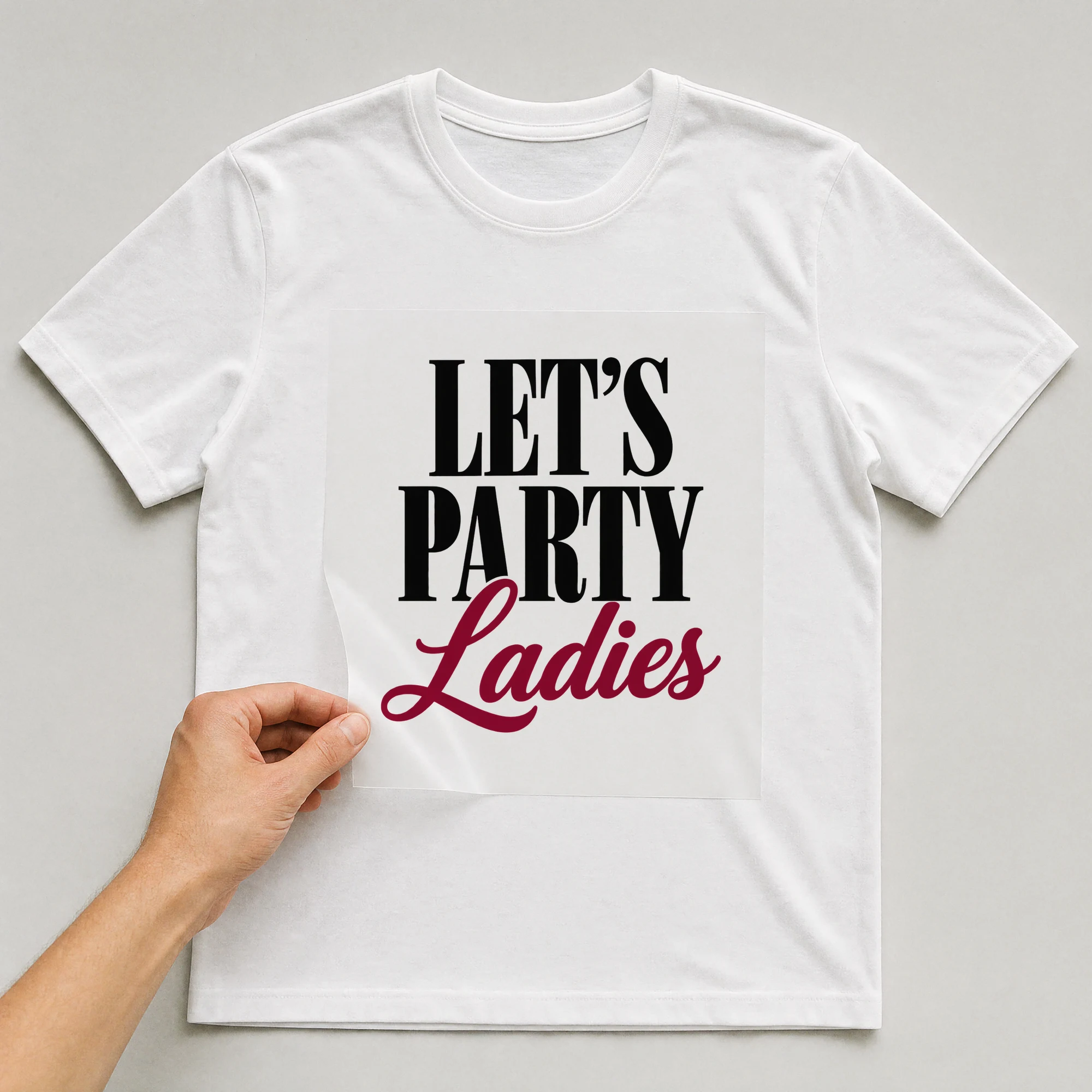 Bügelbild „Let's Party, Ladies“ auf weißem T-Shirt, Folie wird aufgelegt