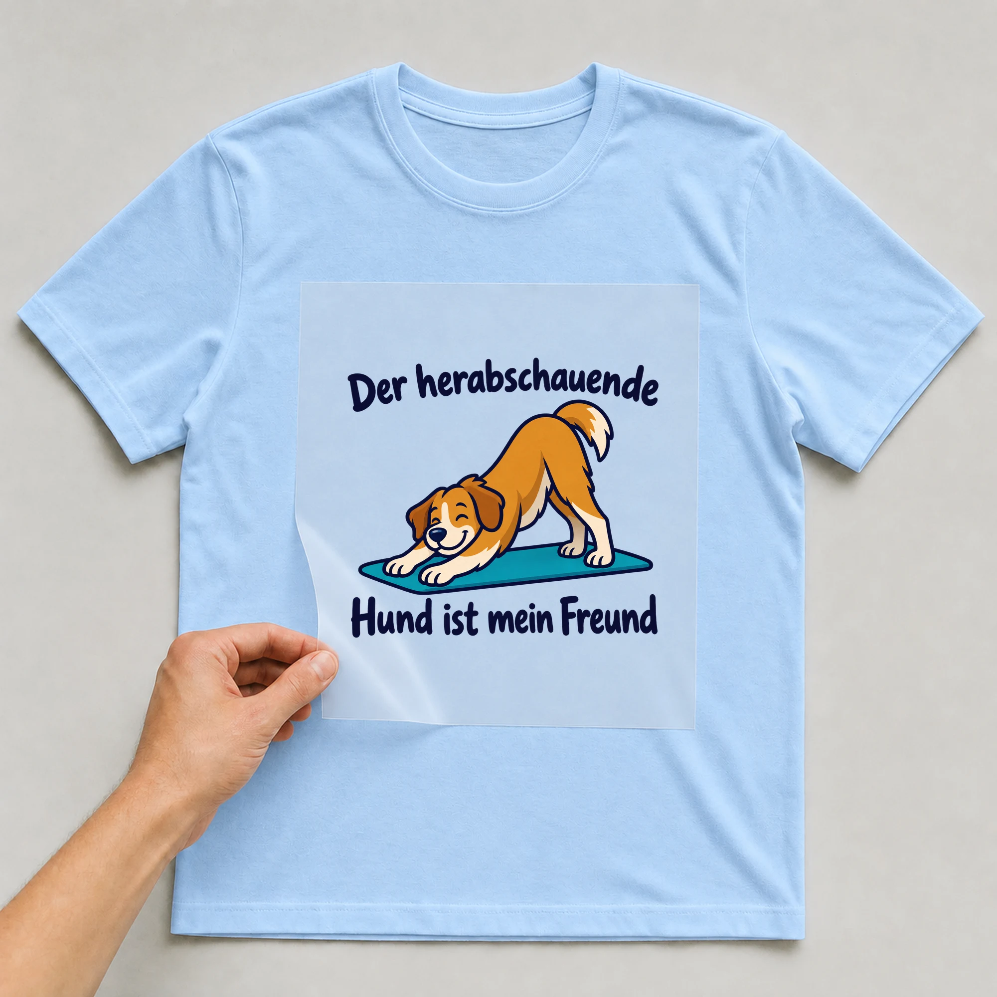 Bügelbild „Der herabschauende Hund ist mein Freund“ auf babyblauem T-Shirt, Folie wird aufgelegt