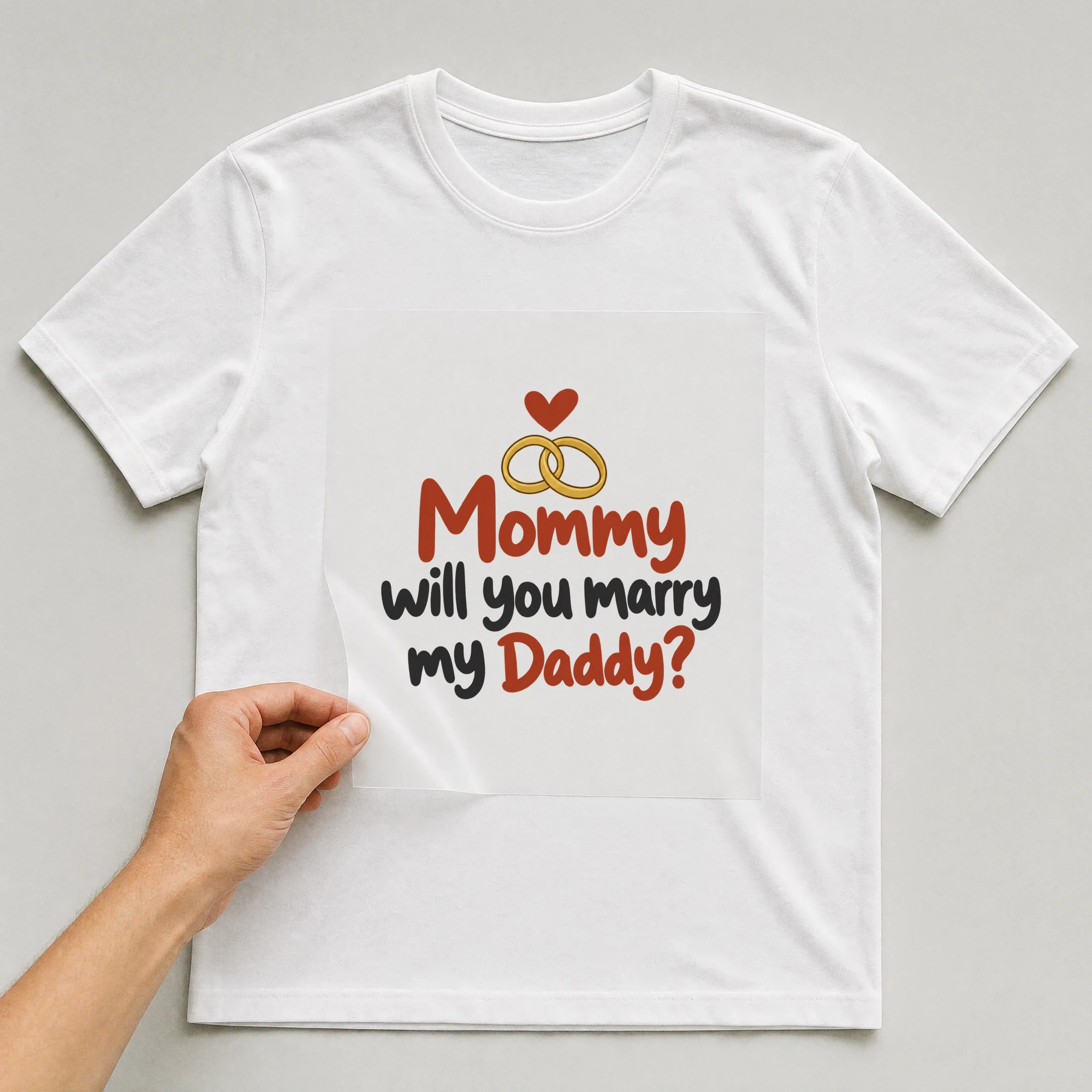 Bügelbild „Mommy will you marry my Daddy?“ auf weißem T-Shirt, Folie wird aufgelegt