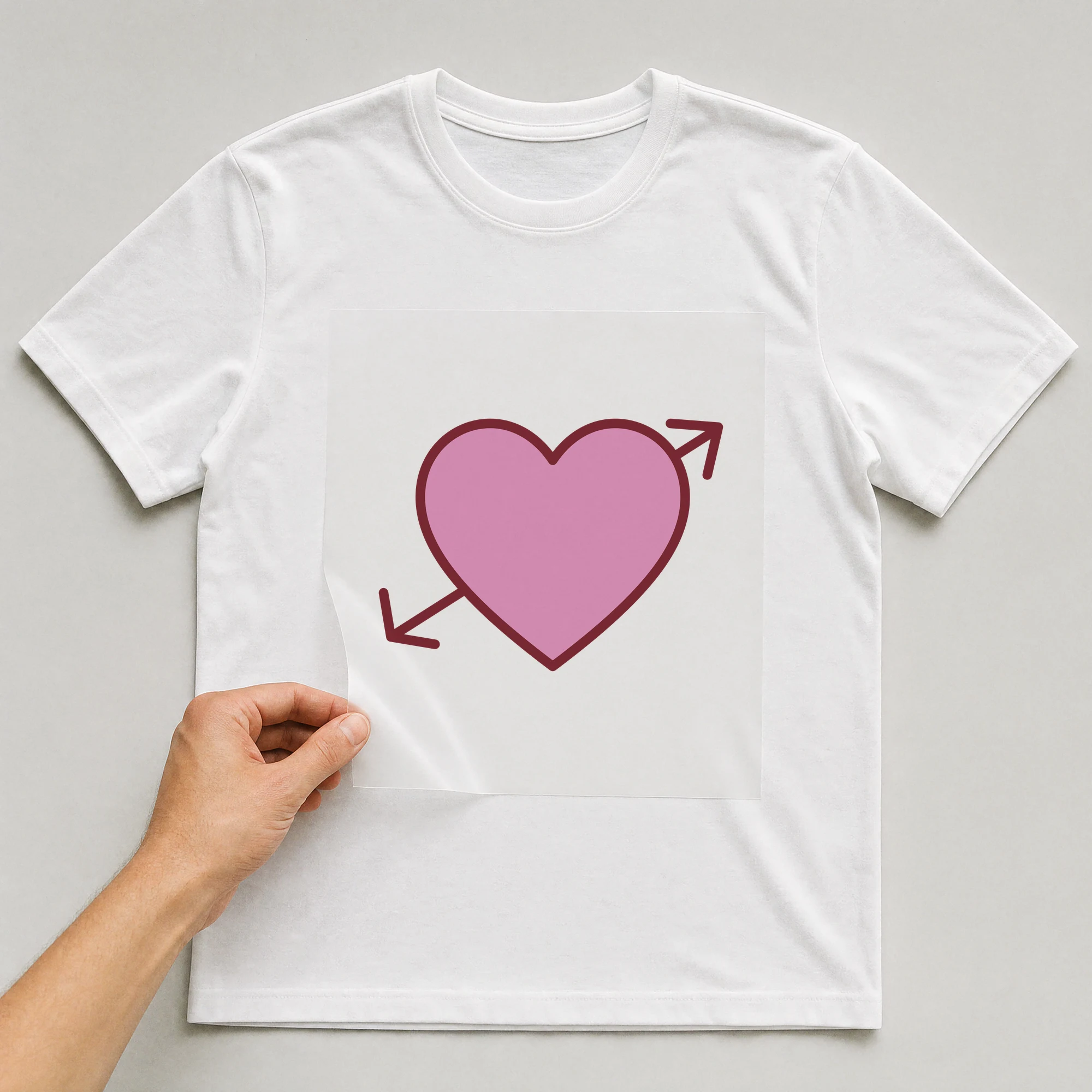 Bügelbild „Herz mit Pfeil“ auf weißem T-Shirt, Folie wird aufgelegt