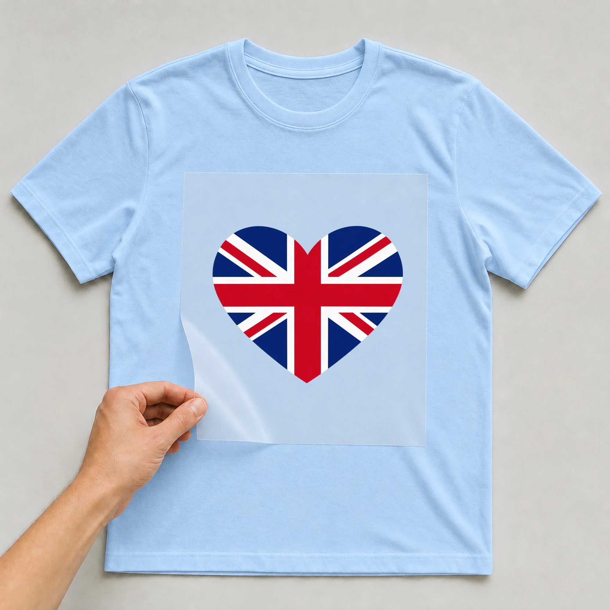 Bügelbild „Herz Flagge Groß Britannien“ auf babyblauem T-Shirt, Folie wird aufgelegt