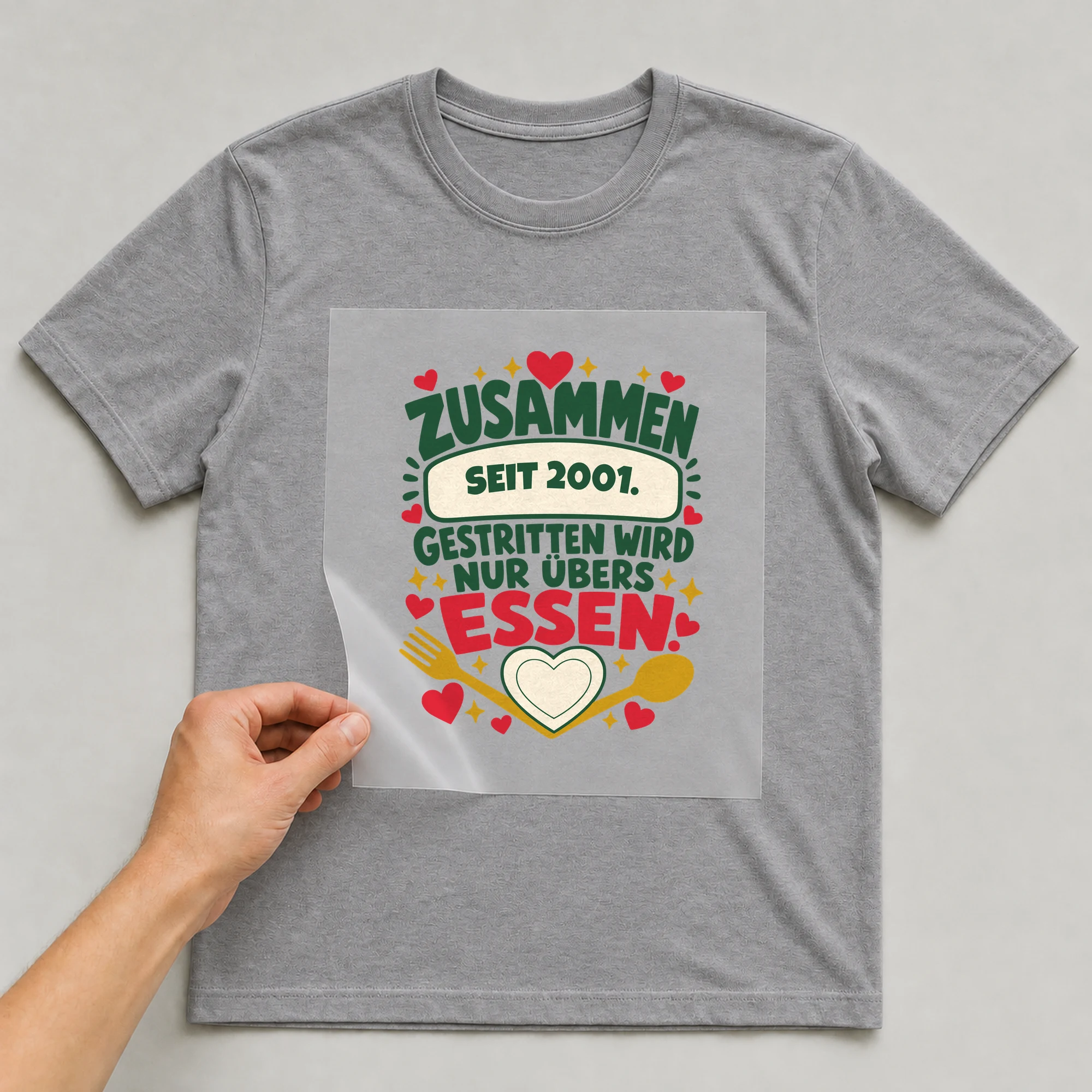Bügelbild Zusammen. Gestritten wird nur übers Essen. mit Jahr auf grauem T-Shirt, Folie wird aufgelegt
