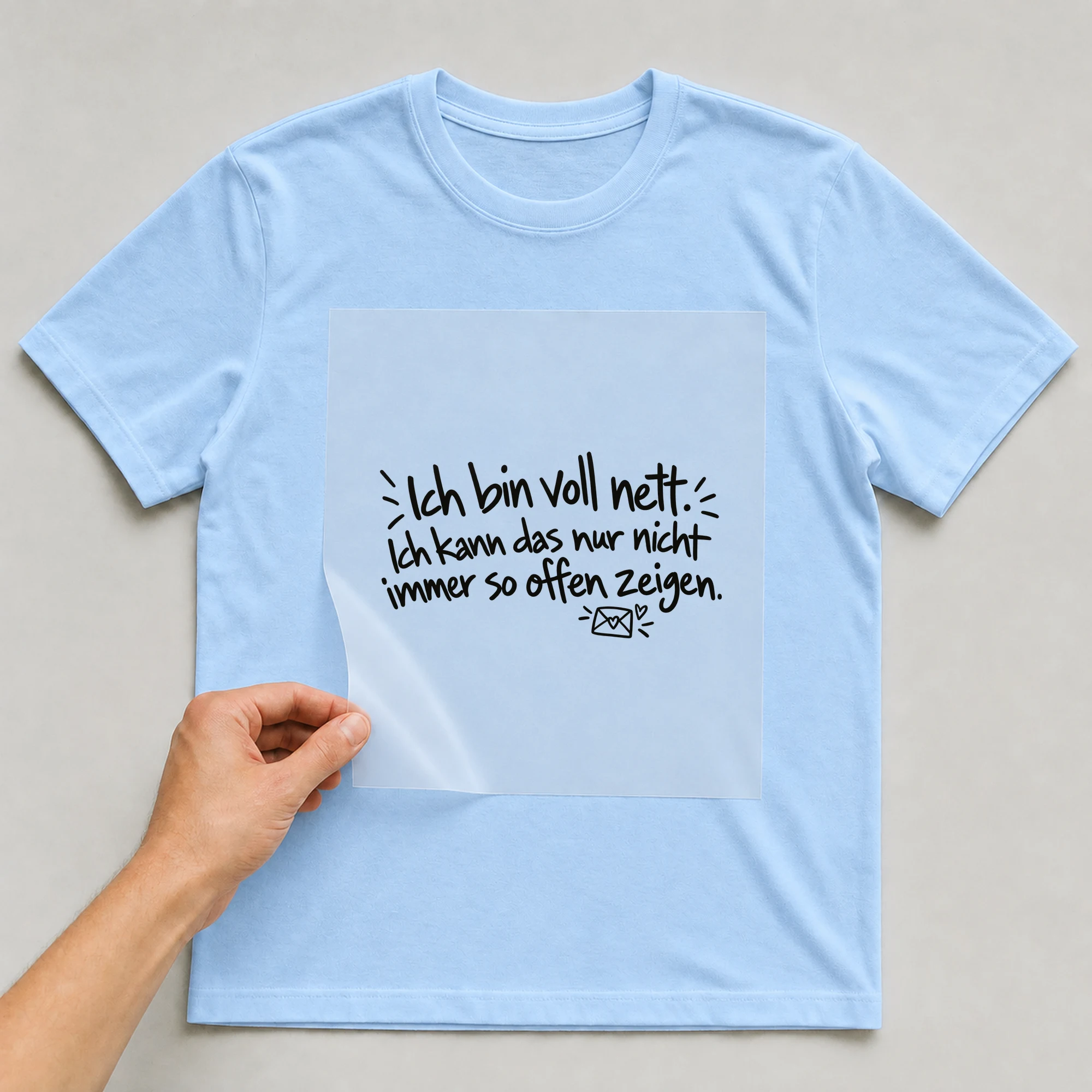 Bügelbild „Ich bin voll nett. Ich kann das nur nicht zeigen.“ auf babyblauem T-Shirt, Folie wird aufgelegt