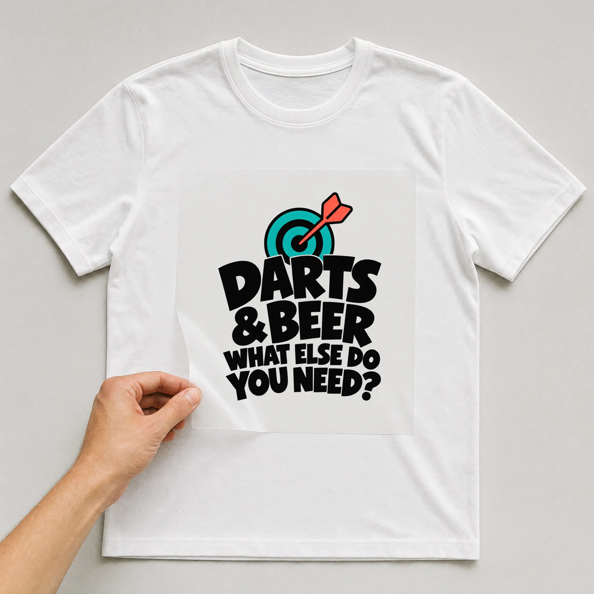 Bügelbild „Darts & Beer What Else Do You Need?“ auf weißem T-Shirt, Folie wird aufgelegt
