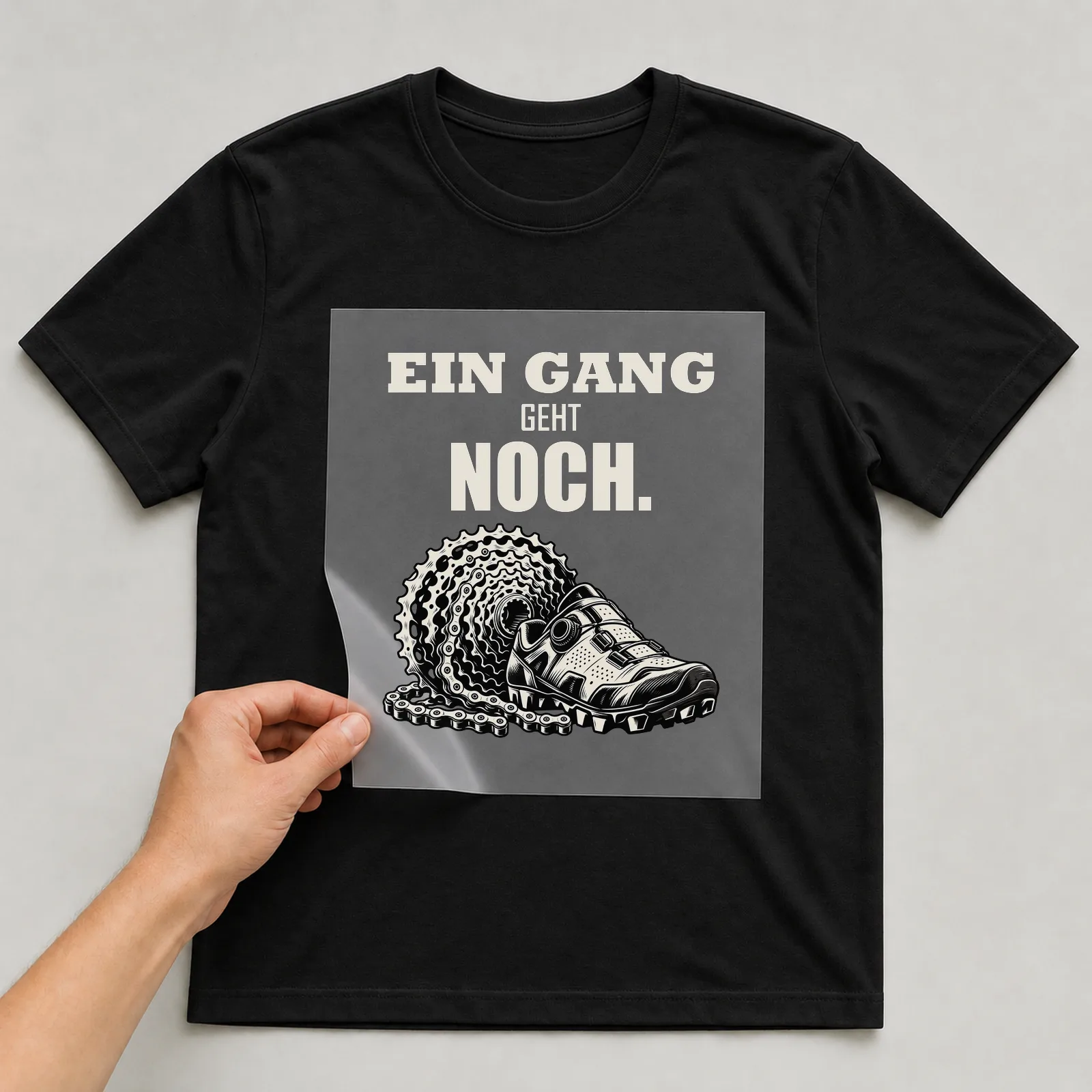 Bügelbild „Ein Gang geht noch“ auf schwarzem T-Shirt, Folie wird aufgelegt