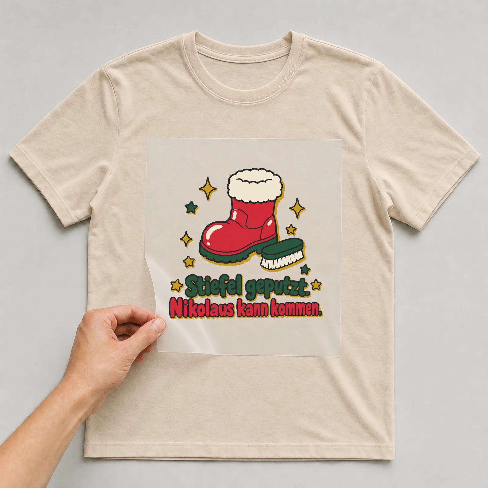 Bügelbild Stiefel geputzt. Nikolaus kann kommen. auf beigem T-Shirt, Folie wird aufgelegt