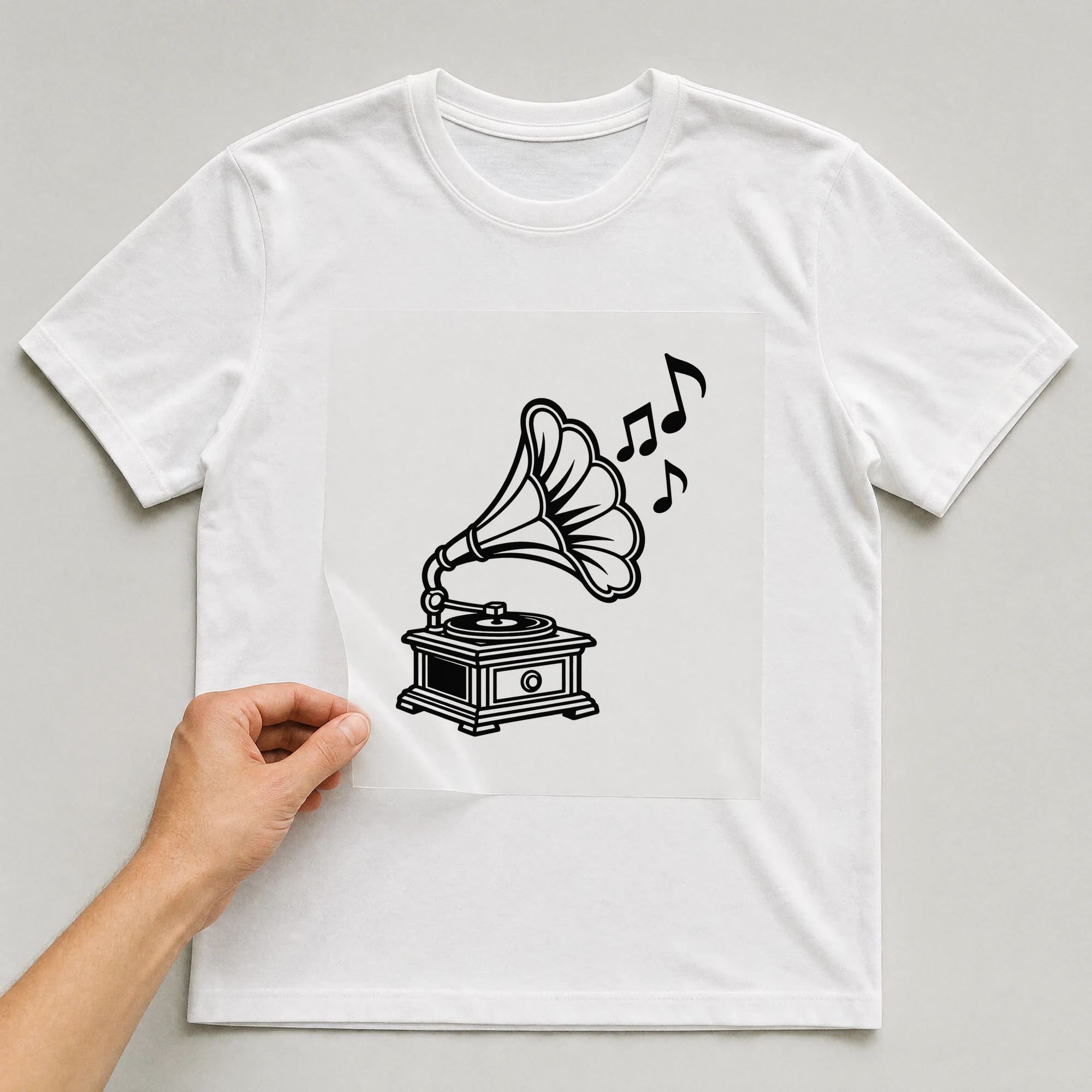 Bügelbild „Musiknoten Grammofon“ auf weißem T-Shirt, Folie wird aufgelegt