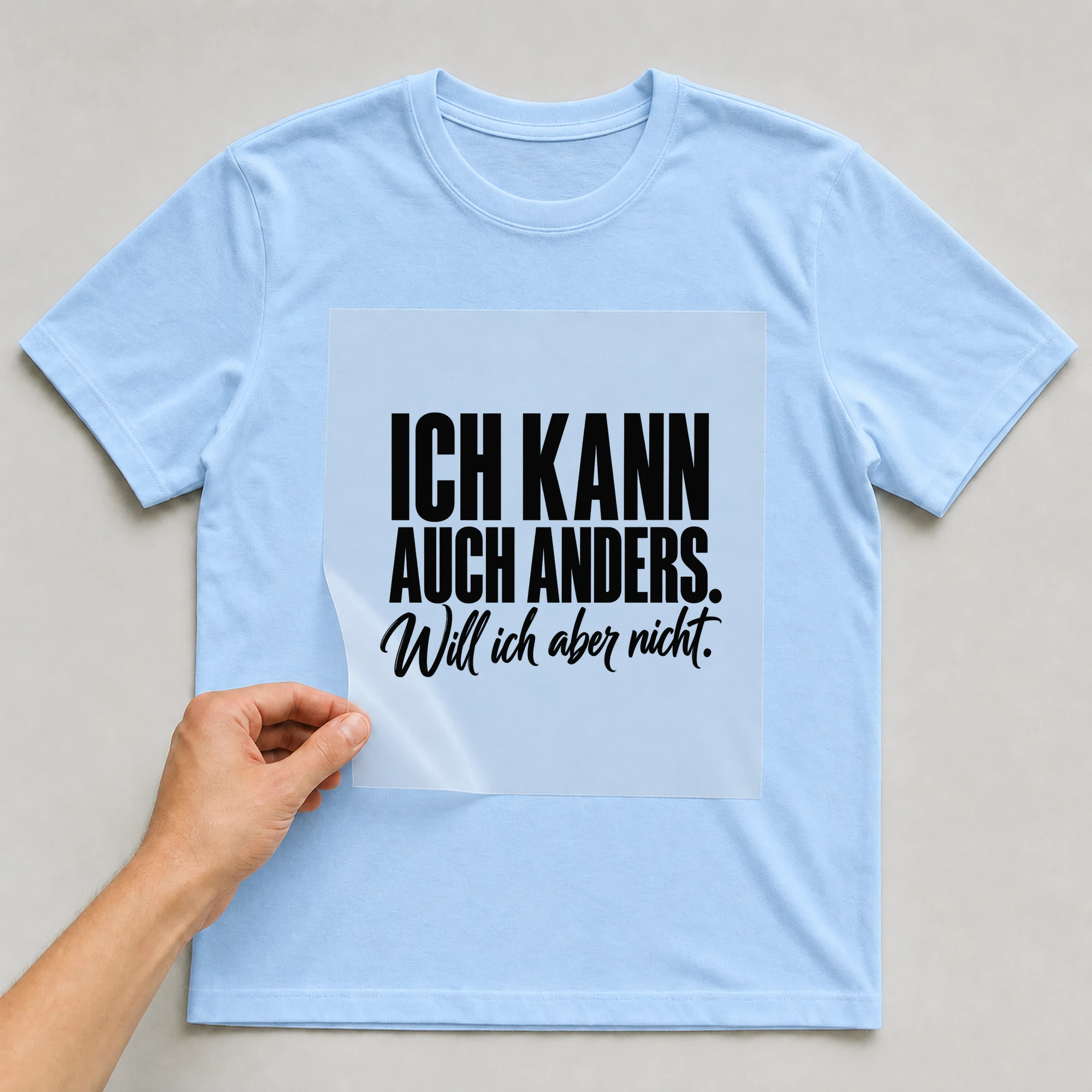 Bügelbild „Ich kann auch anders. Will ich aber nicht.“ auf babyblauem T-Shirt, Folie wird aufgelegt