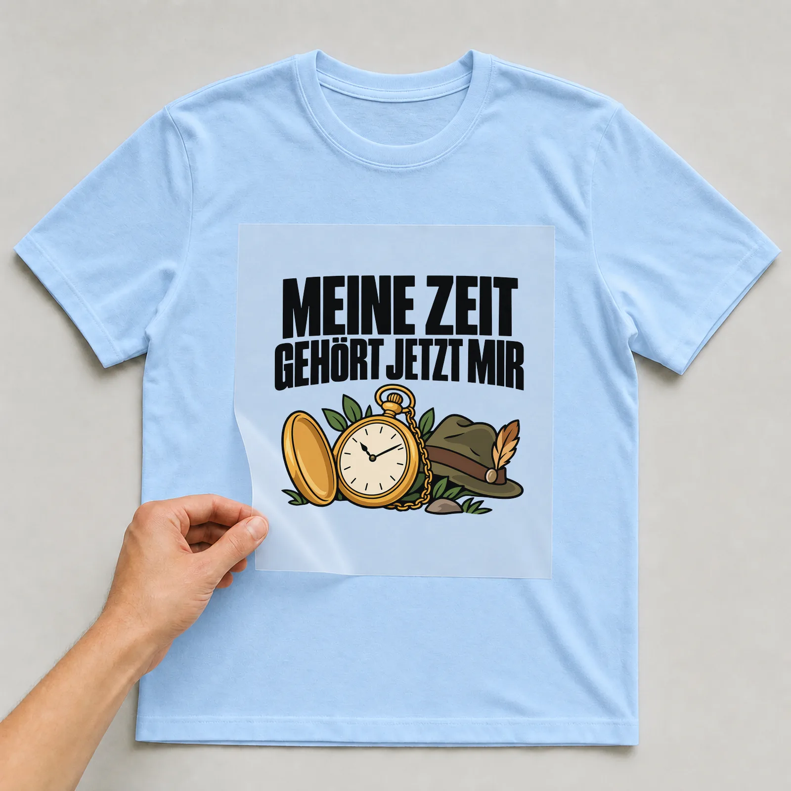 Bügelbild „Meine Zeit gehört jetzt mir“ auf hellblauem T-Shirt, Folie wird aufgelegt