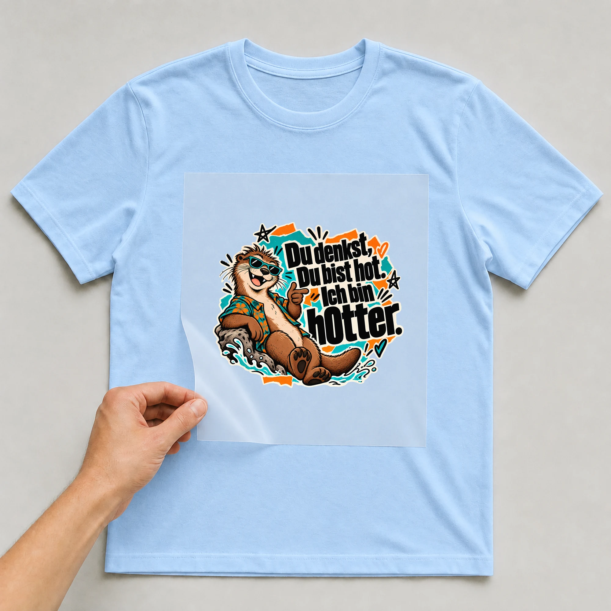 Bügelbild „Du denkst, Du bist hot. Ich bin hOtter.“ auf babyblauem T-Shirt, Folie wird aufgelegt