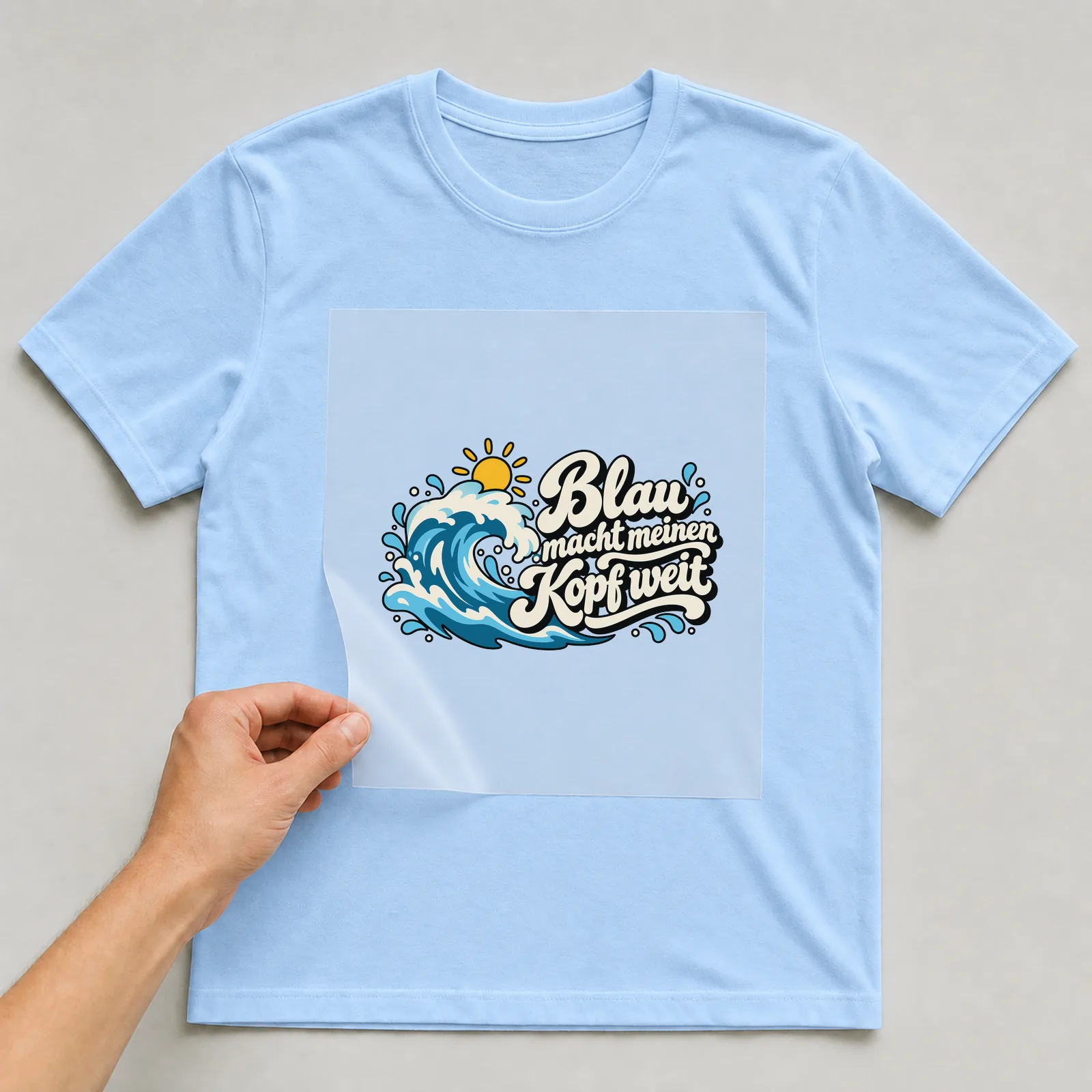 Bügelbild „Blau macht meinen Kopf weit“ auf hellblauem T-Shirt, Folie wird aufgelegt