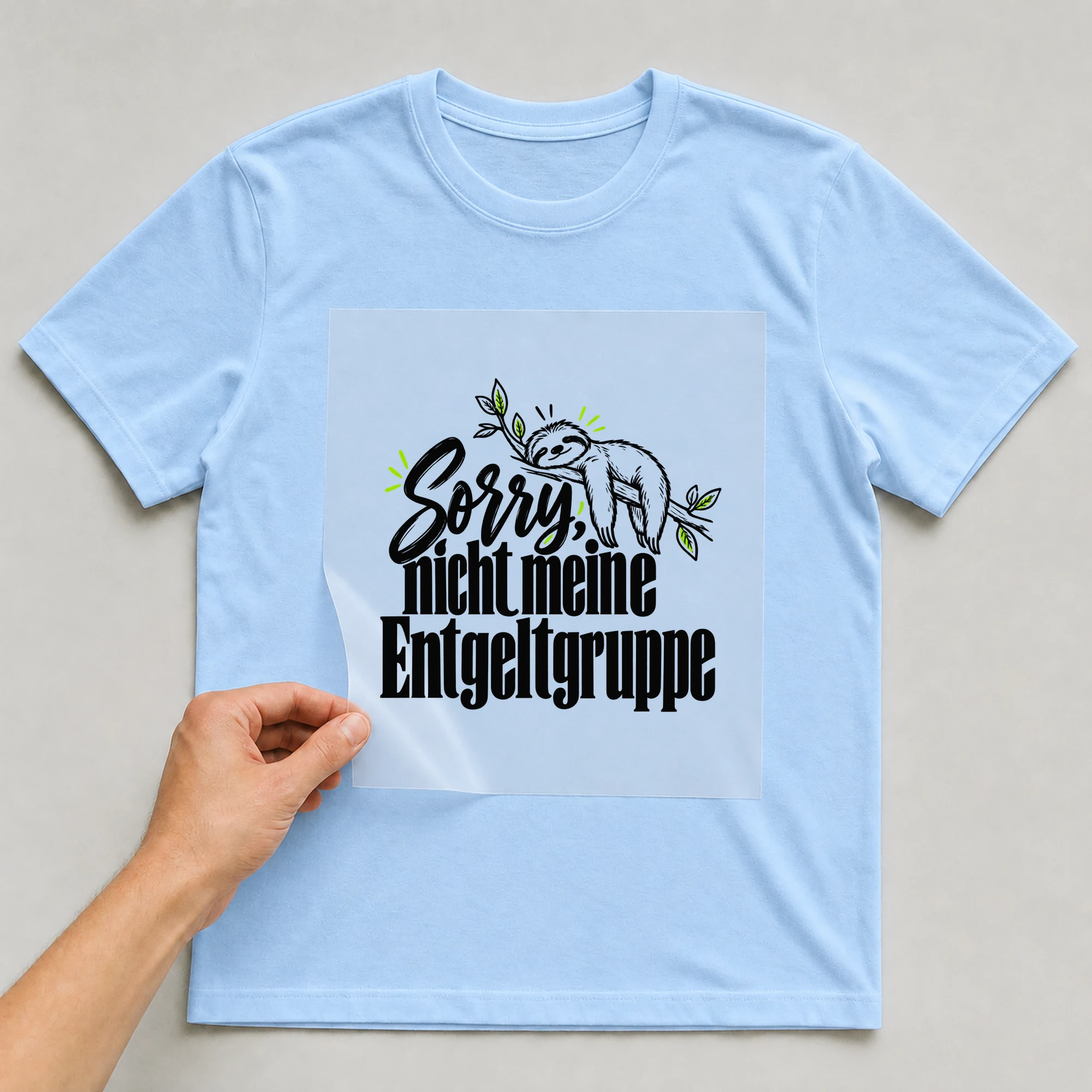 Bügelbild „Sorry, nicht meine Entgeltgruppe“ auf babyblauem T-Shirt, Folie wird aufgelegt
